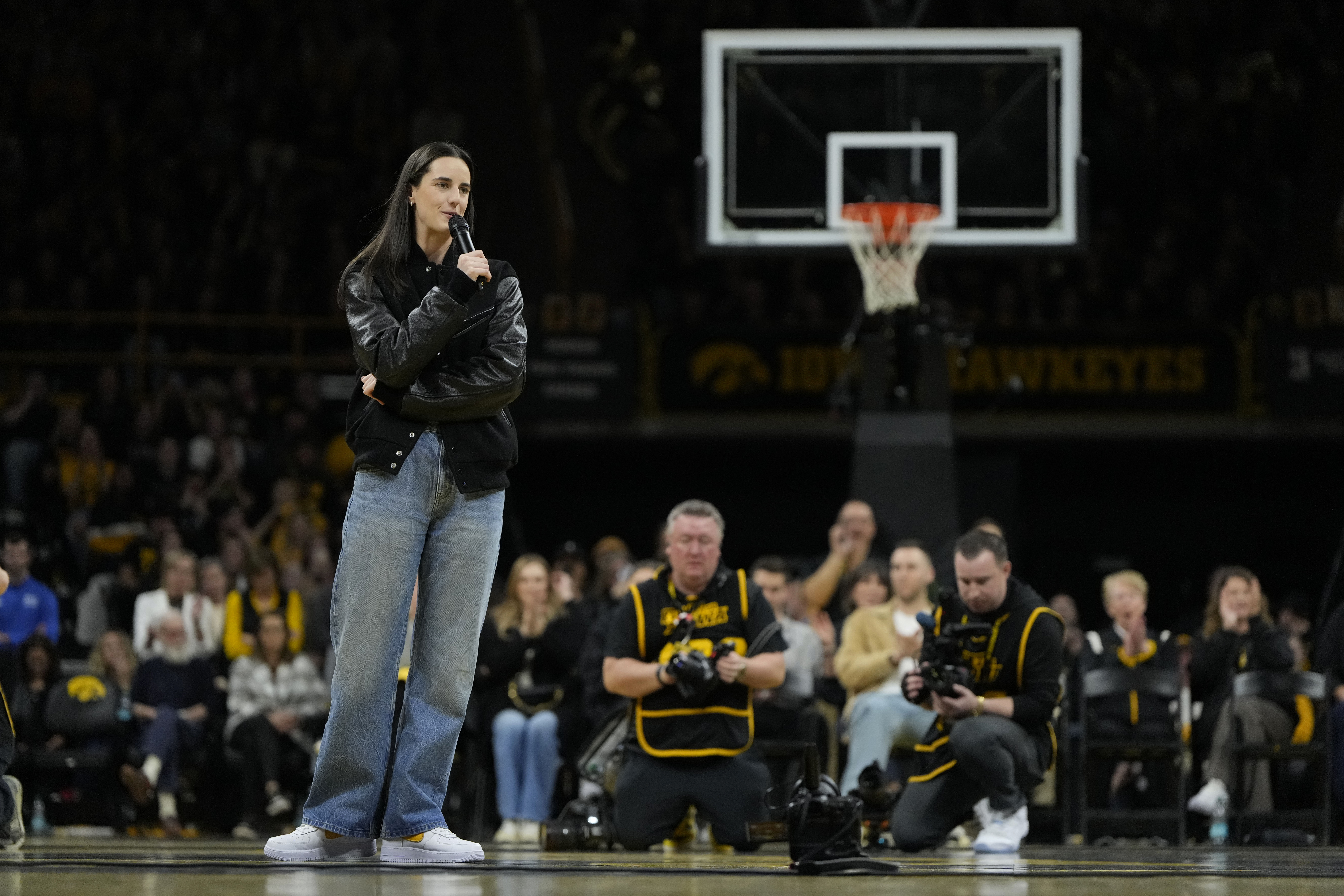 Former Iowa guard and current Indiana Fever WNBA player Caitlin Clark, front left, speaks during her jersey retirement ceremony after an NCAA college basketball game between Iowa and Southern California, Sunday, Feb. 2, 2025, in Iowa City, Iowa.