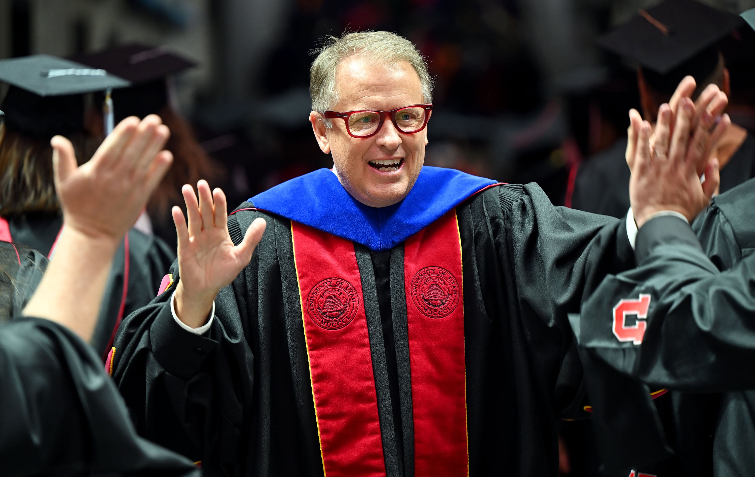 University President Taylor Randall high-fives all the graduates as they file out after commencement at the University of Utah in Salt Lake City on May 2, 2024.