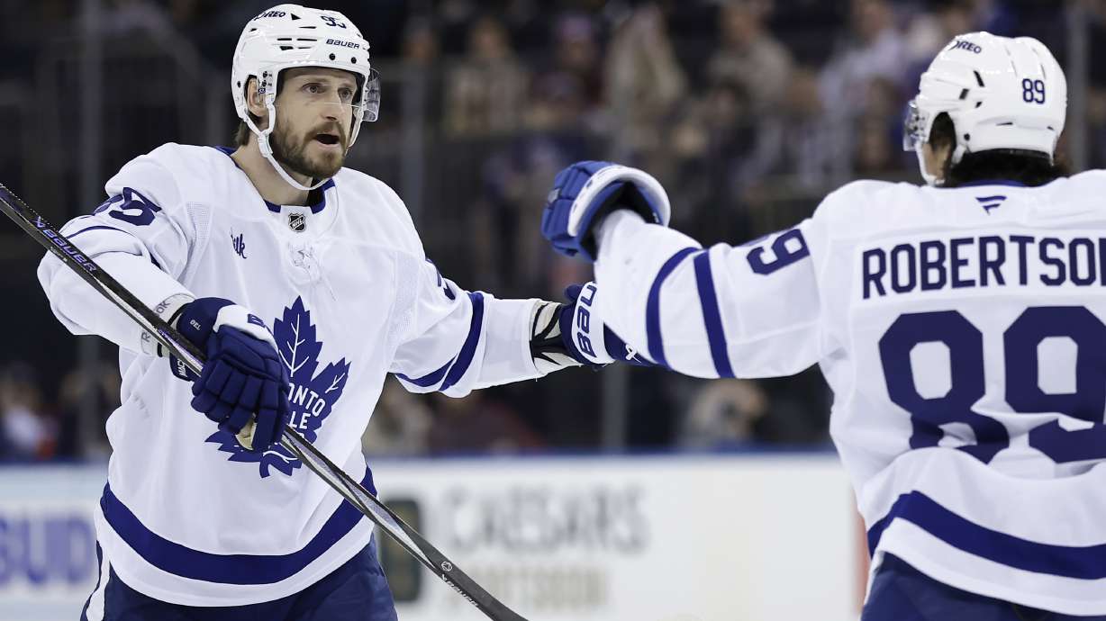 Toronto Maple Leafs defenseman Oliver Ekman-Larsson, left, is congratulated by Nicholas Robertson (89) after scoring in the first period of an NHL hockey game against the New York Rangers, Friday, Feb. 28, 2025, in New York.