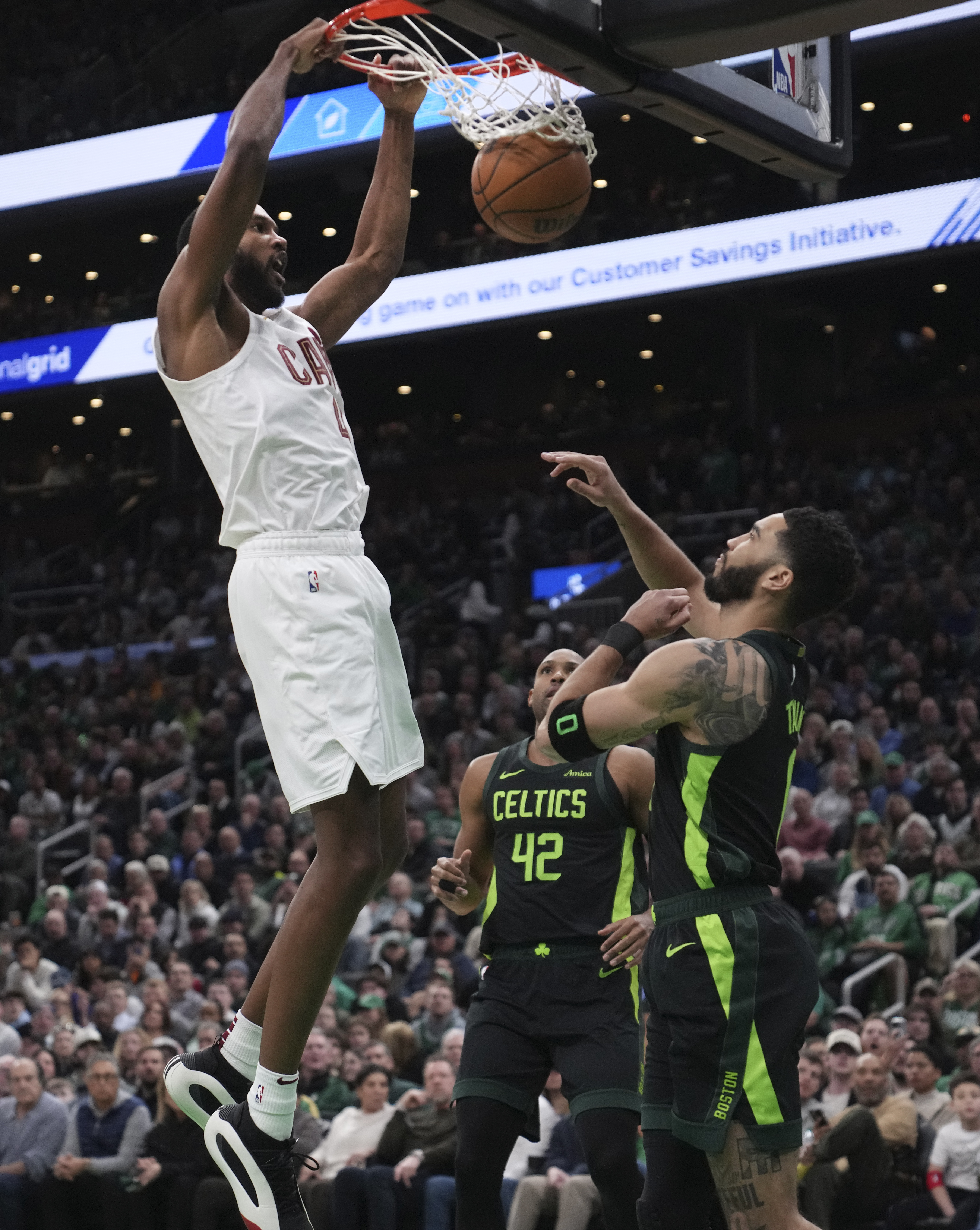 Cleveland Cavaliers forward Evan Mobley, left, slams a dunk over Boston Celtics forward Jayson Tatum, right, during the first half of an NBA basketball game, Friday, Feb. 28, 2025, in Boston. 