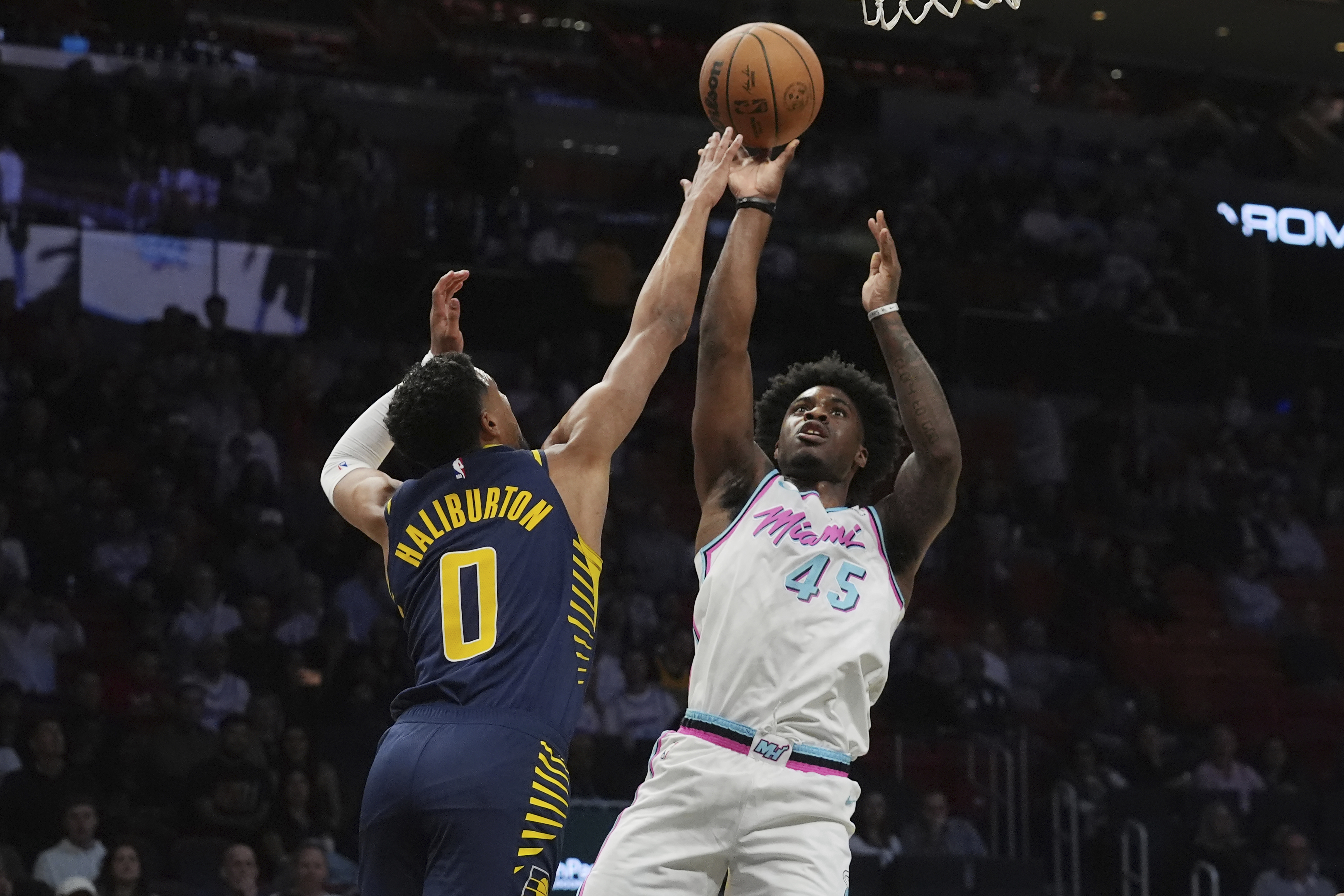 Miami Heat guard Davion Mitchell (45) aims to score as Indiana Pacers guard Tyrese Haliburton (0) defends during the first half of an NBA basketball game, Friday, Feb. 28, 2025, in Miami. 