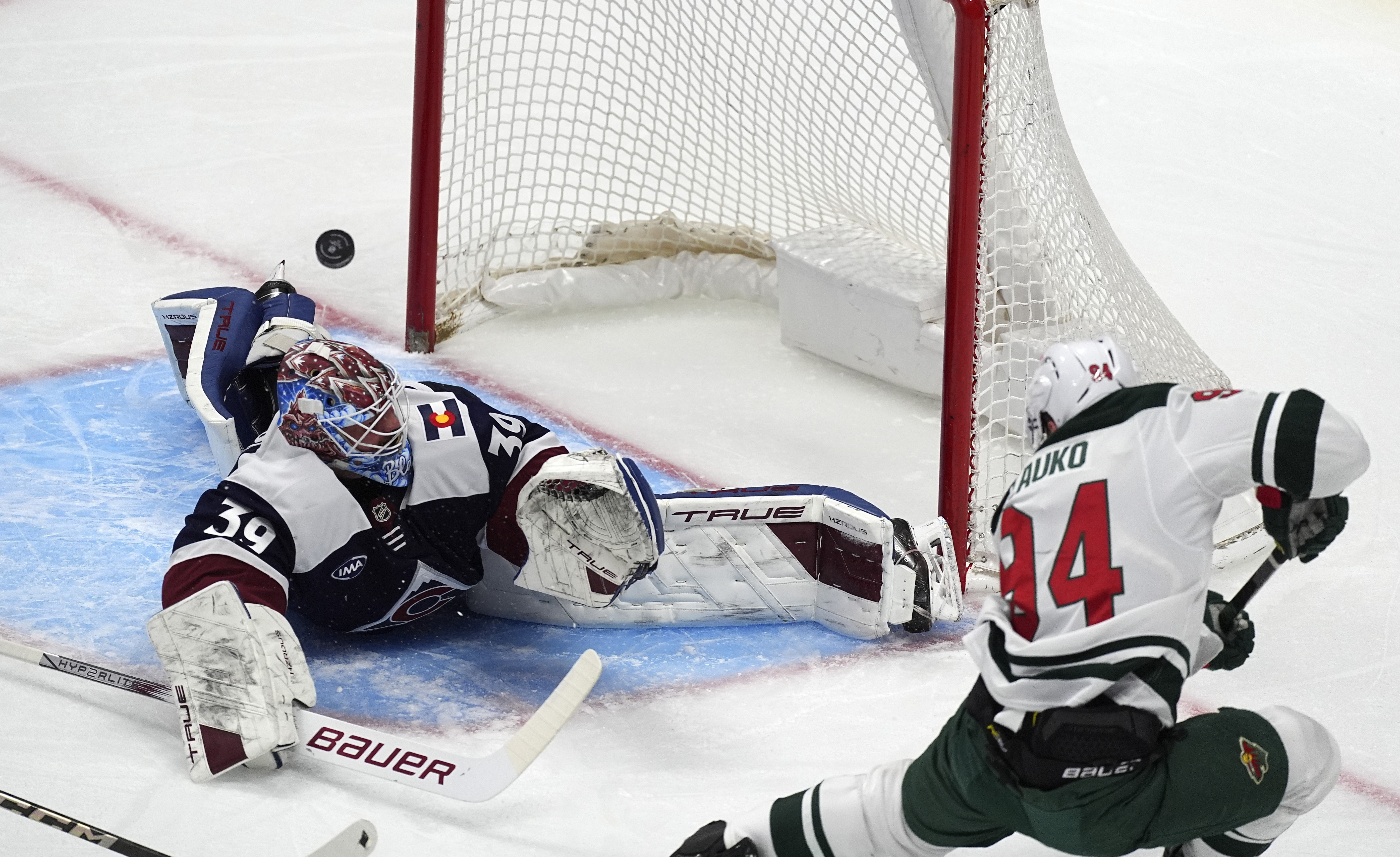 Minnesota Wild center Jakub Lauko, right, puts a shot on Colorado Avalanche goaltender Mackenzie Blackwood in the first period of an NHL hockey game Friday, Feb. 28, 2025, in Denver. 