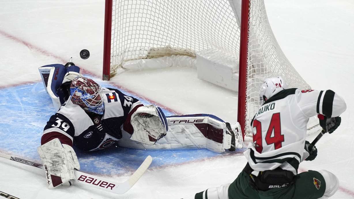 Minnesota Wild center Jakub Lauko, right, puts a shot on Colorado Avalanche goaltender Mackenzie Blackwood in the first period of an NHL hockey game Friday, Feb. 28, 2025, in Denver.