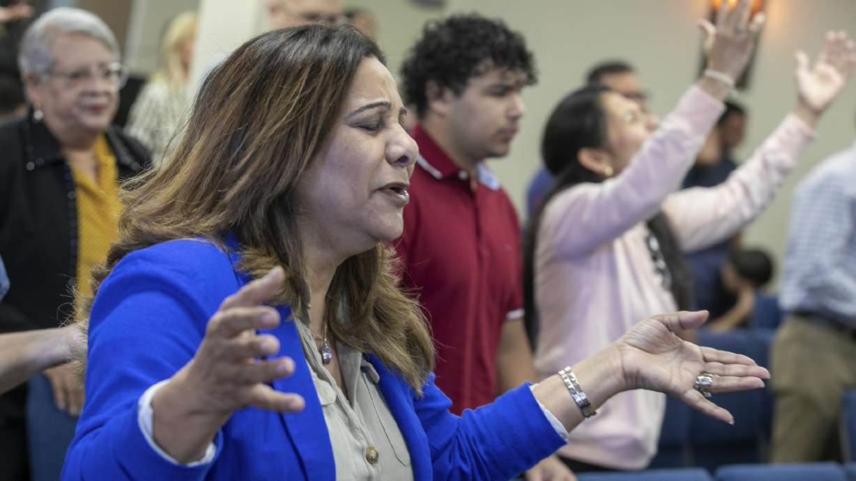 Fatima Guzman prays during a church service at the Centro Cristiano El Pan de Vida, a mid-size Church of God of Prophecy congregation in Kissimmee, Florida, Sunday, Feb. 2, 2025.