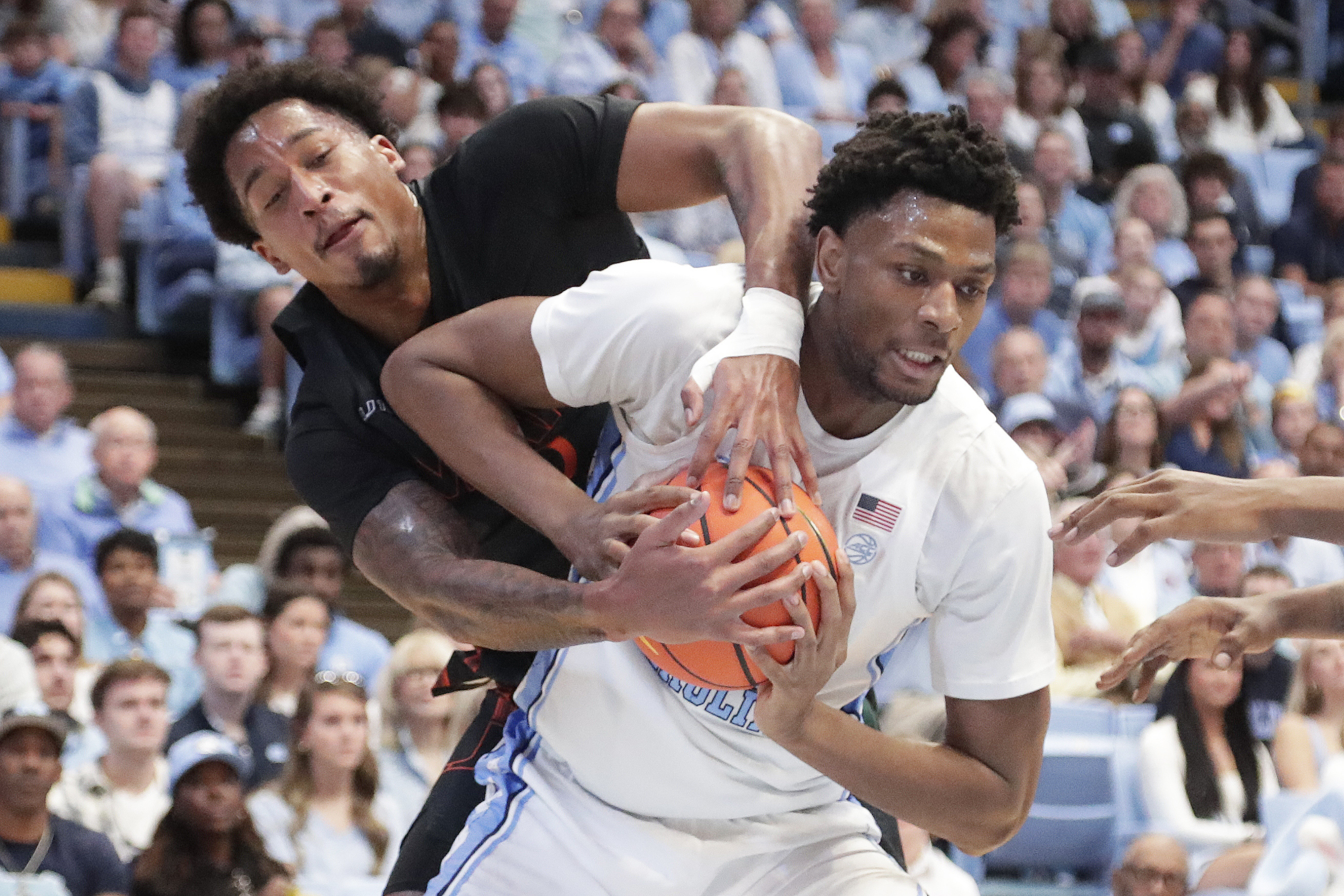 North Carolina forward Jalen Washington, right, battles Miami forward Brandon Johnson (2) for the ball during the first half of an NCAA college basketball game Saturday, March 1, 2025, in Chapel Hill, N.C.