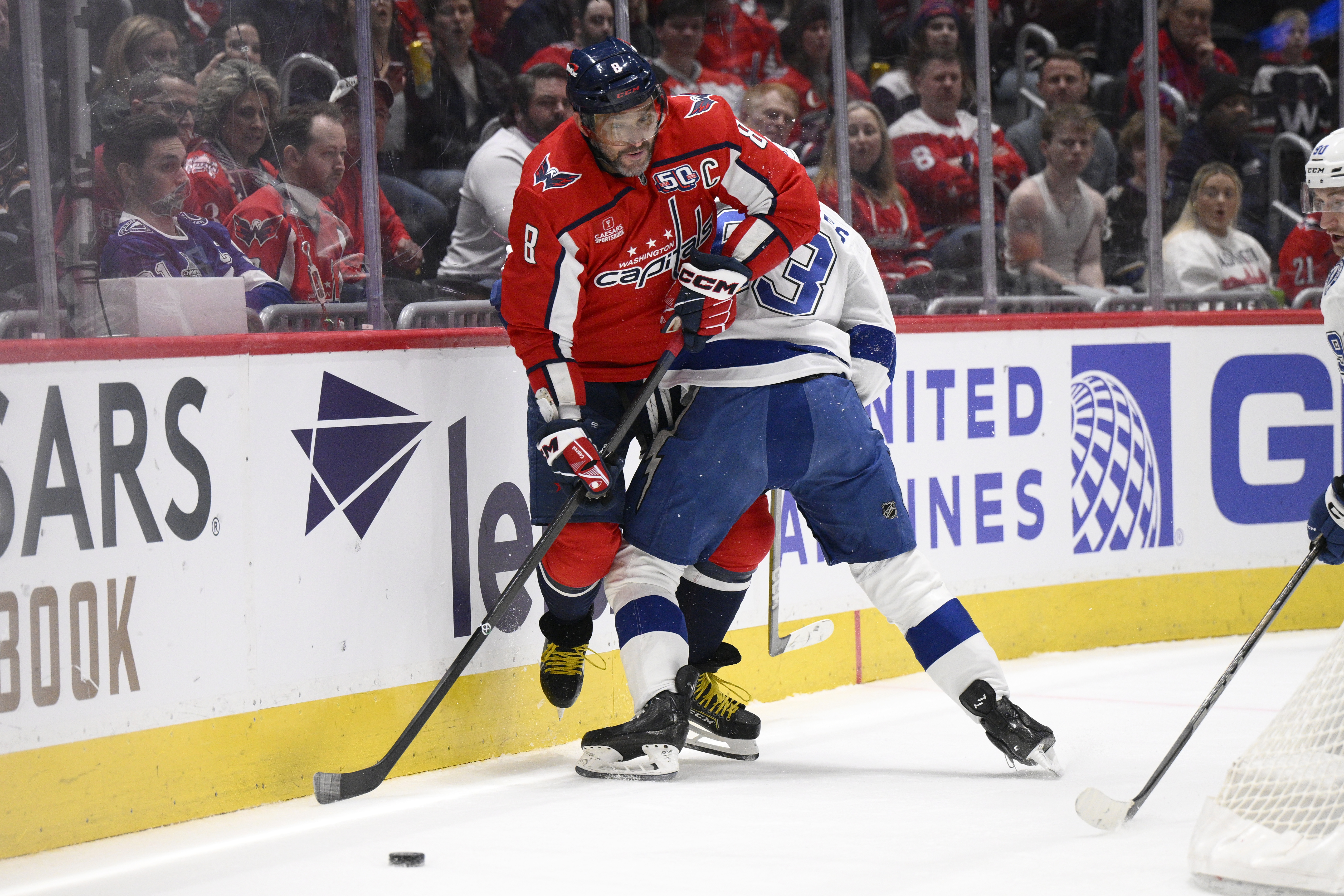Washington Capitals left wing Alex Ovechkin (8) and Tampa Bay Lightning center Gage Goncalves, right, battle along the boards during the first period of an NHL hockey game, Saturday, March 1, 2025, in Washington. 