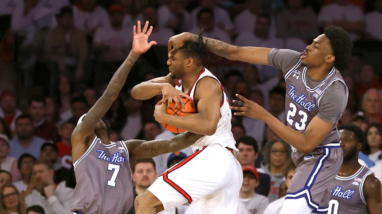 St. John's forward Zuby Ejiofor (24) grabs a rebound against Seton Hall forward Scotty Middleton (7) and center Emmanuel Okorafor (23) during the first half of an NCAA college basketball game, Saturday, March 1, 2025, in New York.