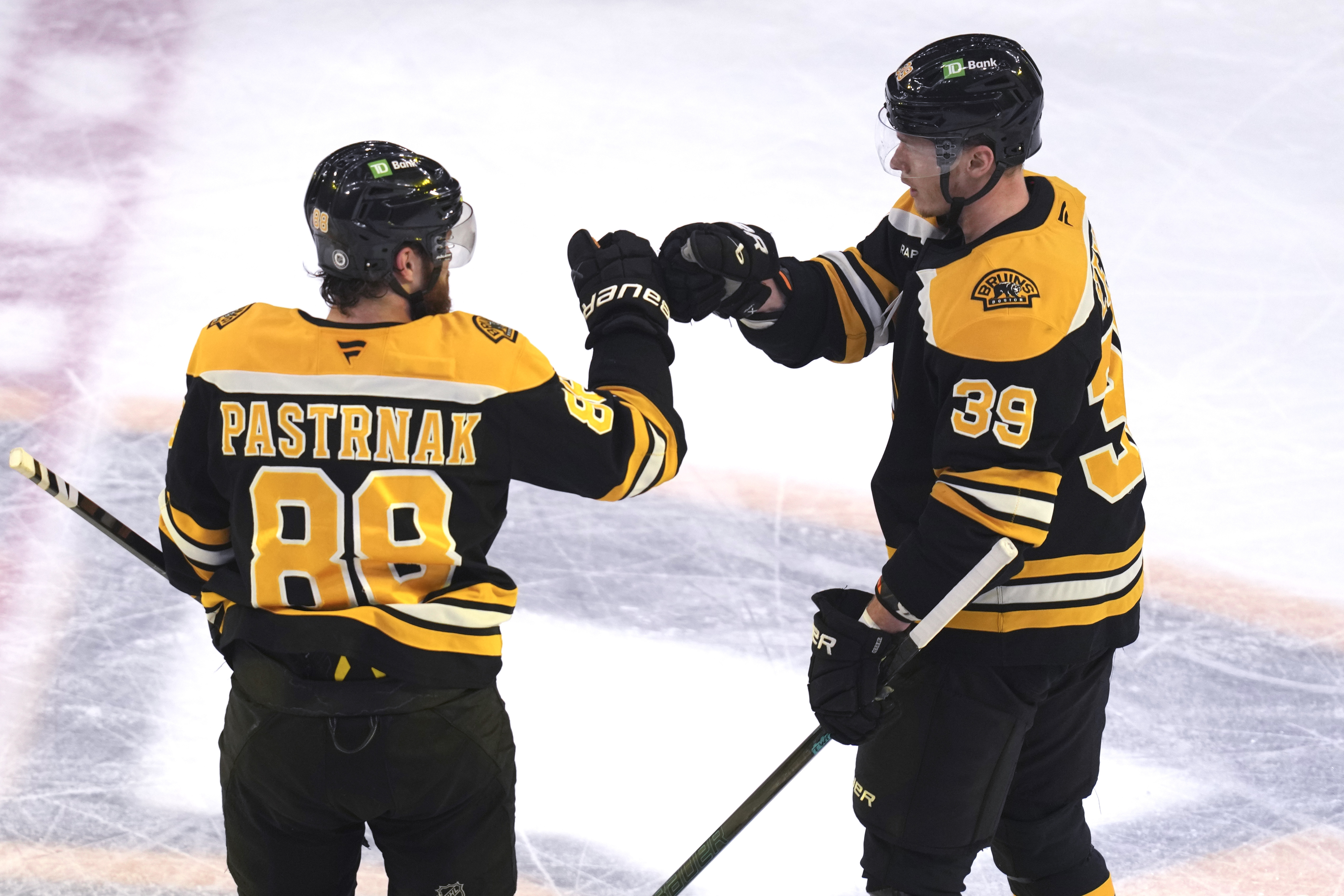 Boston Bruins center Morgan Geekie (39) is congratulated by David Pastrnak (88) after his goal against the Minnesota Wild during the third period of an NHL hockey game, Tuesday, Feb. 4, 2025, in Boston. 