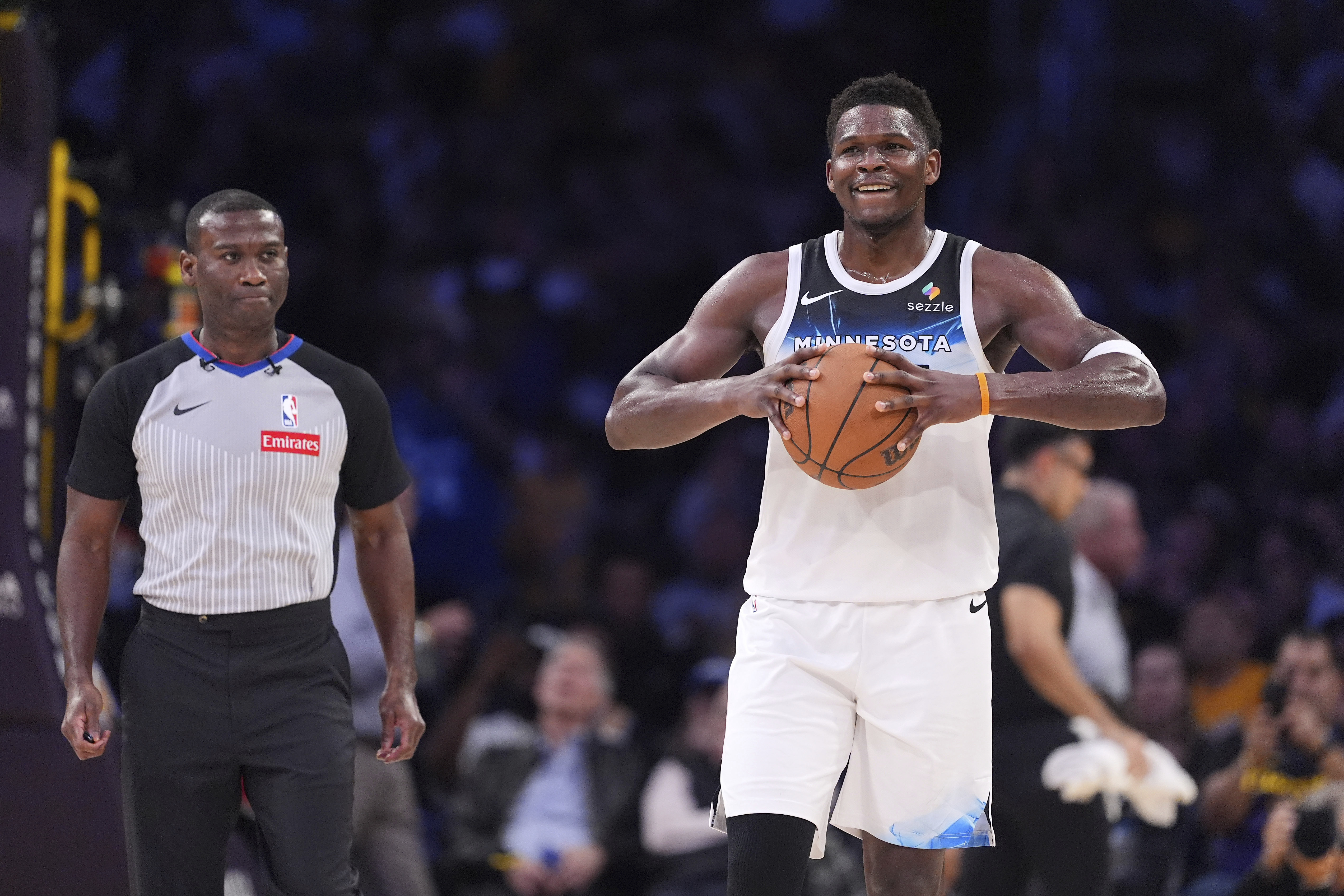 Minnesota Timberwolves guard Anthony Edwards holds the ball as a referee follows after he was ejected during the second half of an NBA basketball game against the Los Angeles Lakers, Thursday, Feb. 27, 2025, in Los Angeles.