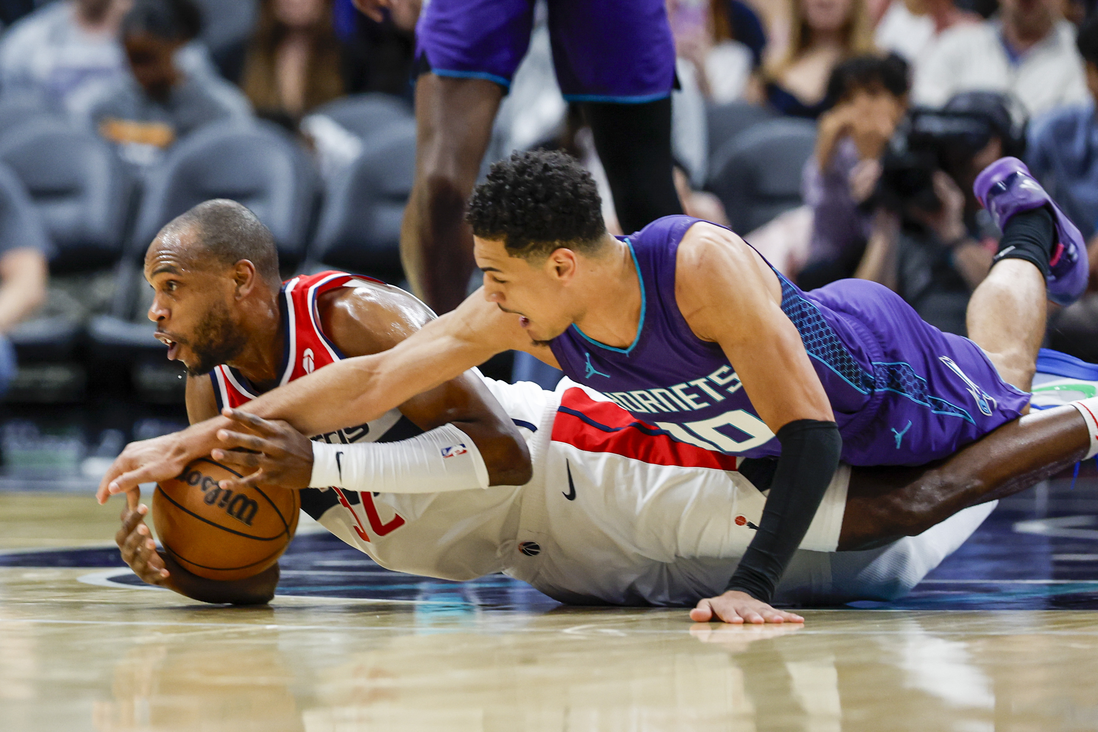 Washington Wizards forward Khris Middleton, left, and Charlotte Hornets guard Josh Green battle for a loose ball during the first half of an NBA basketball game in Charlotte, N.C., Saturday, March 1, 2025. 