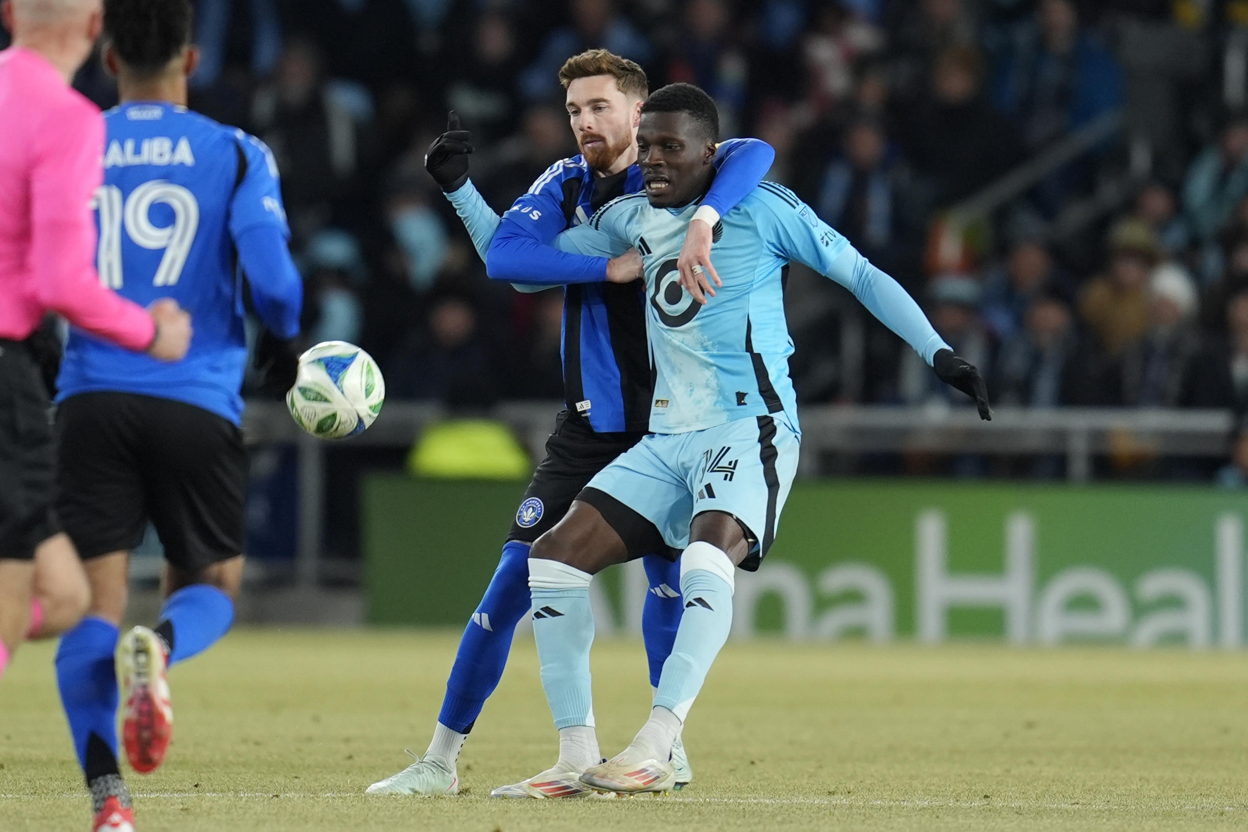 Minnesota United forward Tani Oluwaseyi (14) and CF Montreal defender Joel Waterman, center left, battle for possession during the first half of an MLS soccer match in St. Paul, Minn., Saturday, March 1, 2025. 