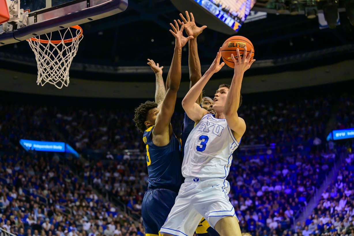 BYU guard Egor Demin (3) shoots the ball defended by West Virginia forward Amani Hansberry, left, and center Eduardo Andre, rear, during the first half of an NCAA basketball game, Saturday, March 1, 2025, in Provo, Utah.