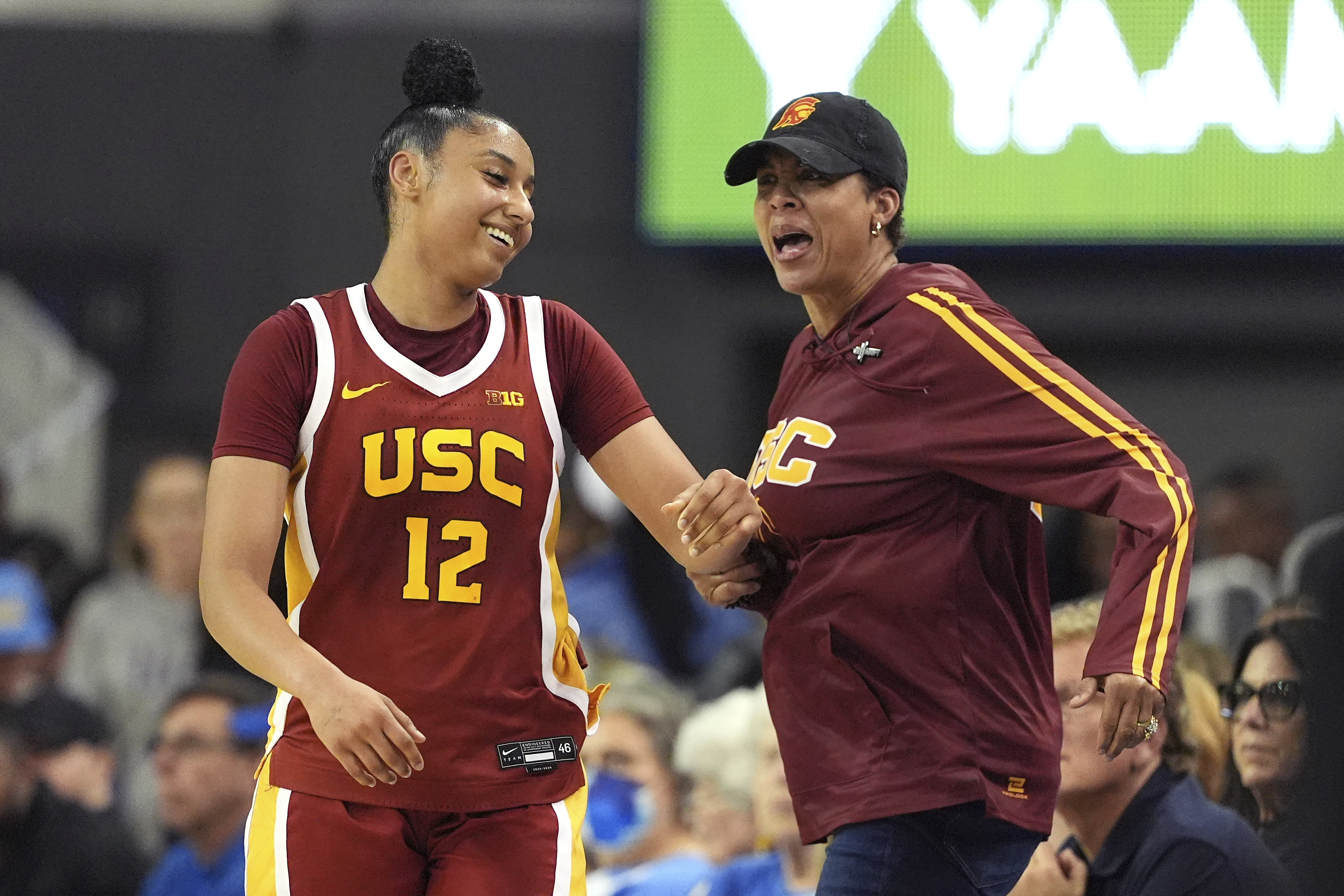 Southern California guard JuJu Watkins, left, reacts to getting a slap on the behind from former USC player Cheryl Miller after scoring during the second half of an NCAA college basketball game against UCLA Saturday, March 1, 2025, in Los Angeles. 