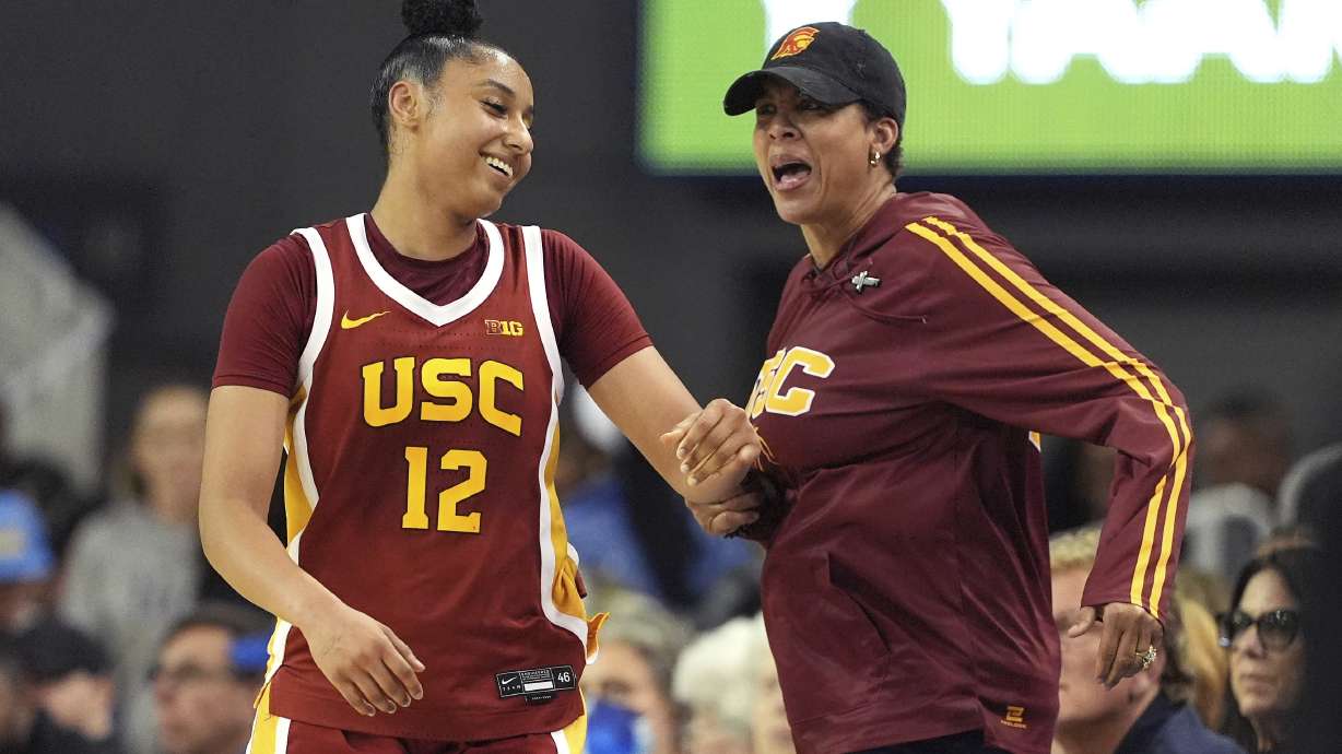 Southern California guard JuJu Watkins, left, reacts to getting a slap on the behind from former USC player Cheryl Miller after scoring during the second half of an NCAA college basketball game against UCLA Saturday, March 1, 2025, in Los Angeles.