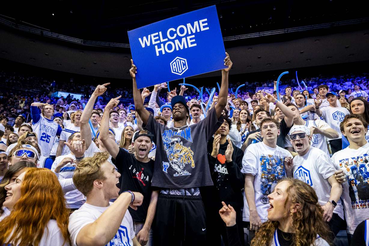 AJ Dybantsa, the nation's No. 1 basketball recruit who has committed to BYU, holds a sign with students at halftime during an NCAA men’s basketball game against the West Virginia Mountaineers held at the Marriott Center in Provo on Saturday, March 1, 2025.