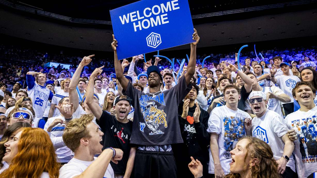 AJ Dybantsa, the nation's No. 1 basketball recruit who has committed to BYU, holds a sign with students at halftime during an NCAA men’s basketball game against the West Virginia Mountaineers held at the Marriott Center in Provo on Saturday, March 1, 2025.