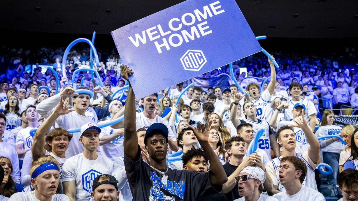 AJ Dybantsa, the nation's No. 1 basketball recruit who has committed to BYU, holds a sign with students at halftime during an NCAA men’s basketball game against the West Virginia Mountaineers held at the Marriott Center in Provo on Saturday, March 1, 2025.
