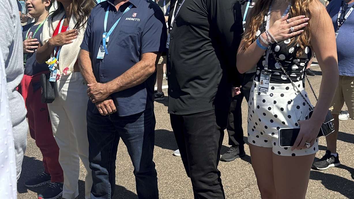 Michael Andretti, third from left, stands with his son, Mario, left, wife Jodi Ann, second from left, and Andretti Global new owner Dan Towriss, second from right, with his wife Cassidy Marie, right, before the Grand Prix of St. Petersburg auto race Sunday, March 2, 2025, in St. Petersburg, Fla.