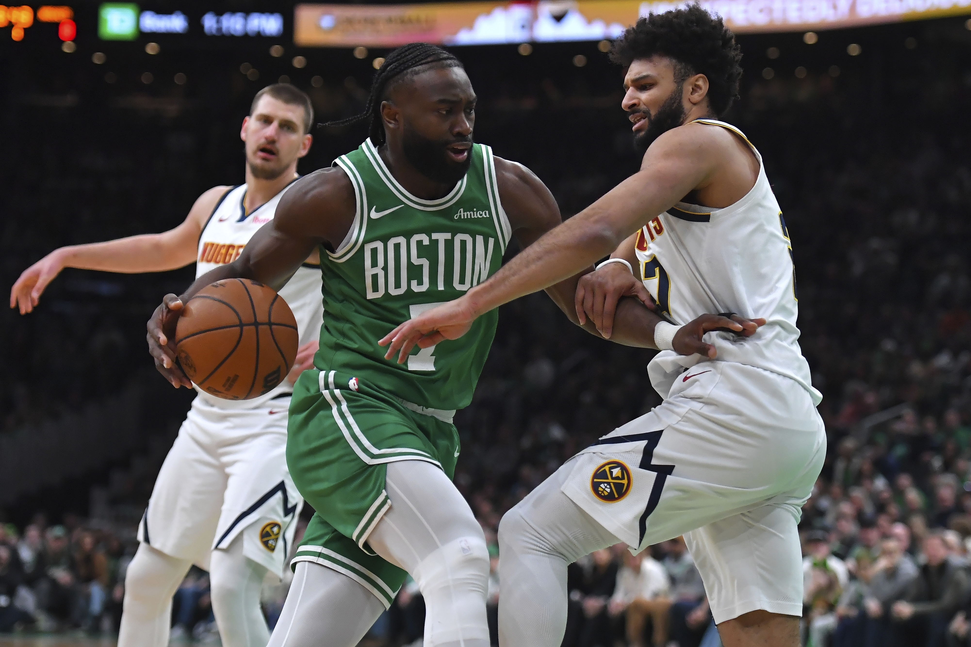 Boston Celtics guard Jaylen Brown, center, drives past Denver Nuggets guard Jamal Murray, right, in the first half of an NBA basketball game, Sunday, March 2, 2025, in Boston. 