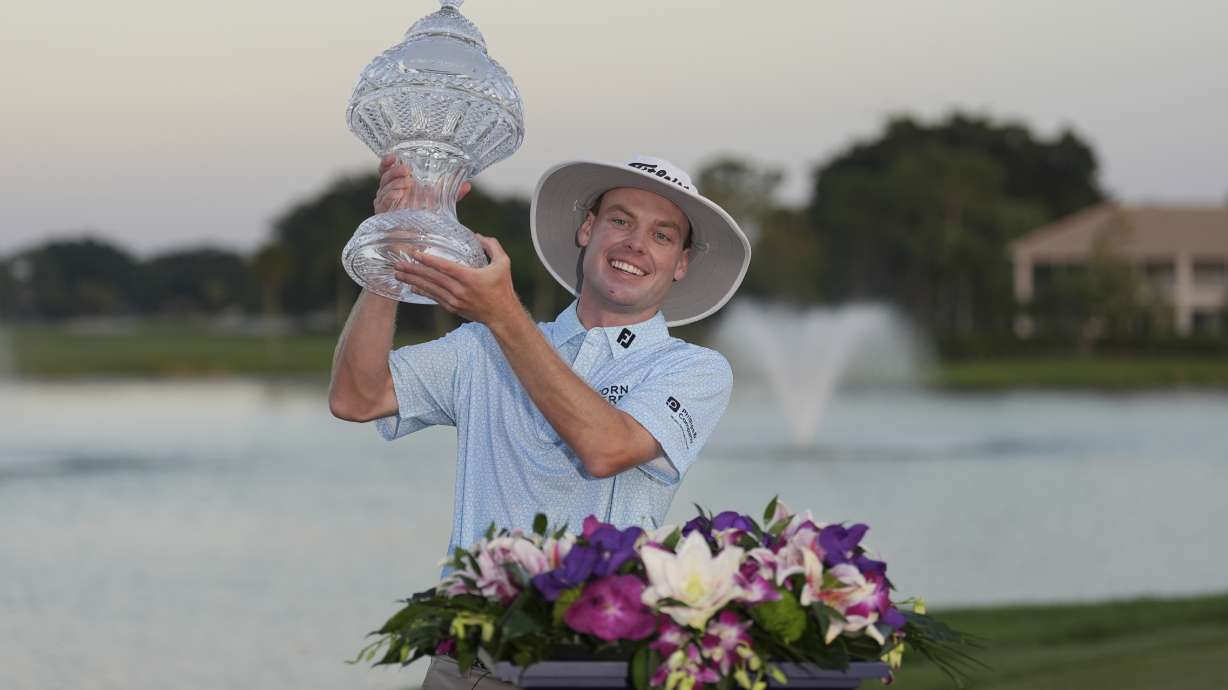 Joe Highsmith hoists his trophy after winning in the final round of the Cognizant Classic golf tournament, Sunday, March 2, 2025, in Palm Beach Gardens, Fla.