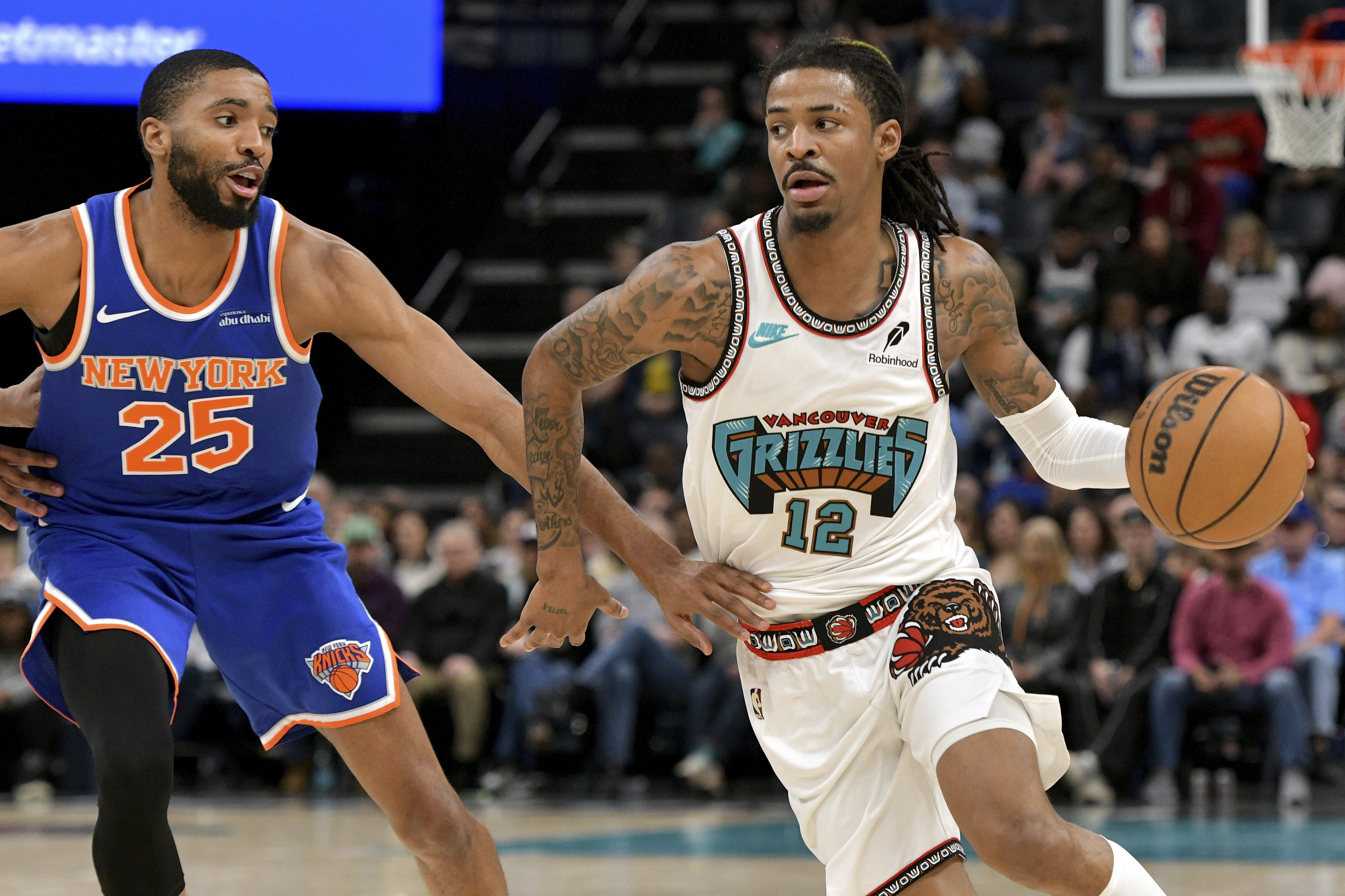 Memphis Grizzlies guard Ja Morant (12) handles the ball against New York Knicks forward Mikal Bridges (25) in the second half of an NBA basketball game Friday, Feb. 28, 2025, in Memphis, Tenn. 