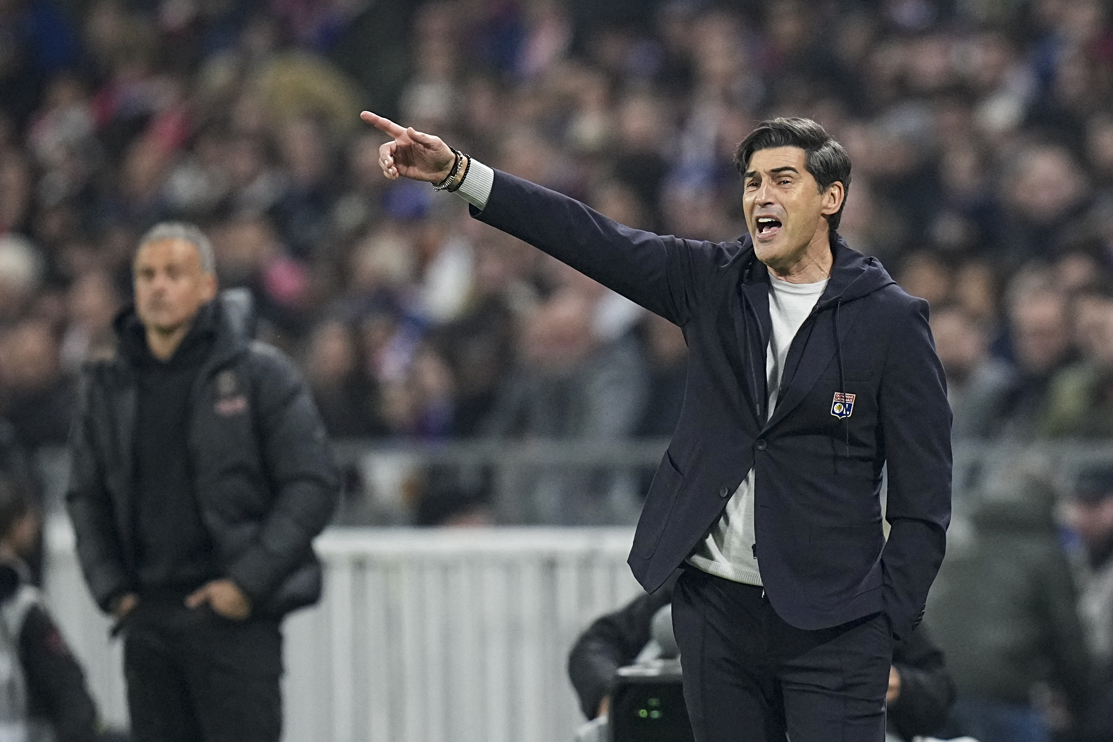 Lyon's head coach Paulo Fonseca gives instructions to his players during the French League One soccer match between Lyon and Paris Saint-Germain at the Groupama stadium, outside Lyon, France, Sunday, Feb. 23, 2025.
