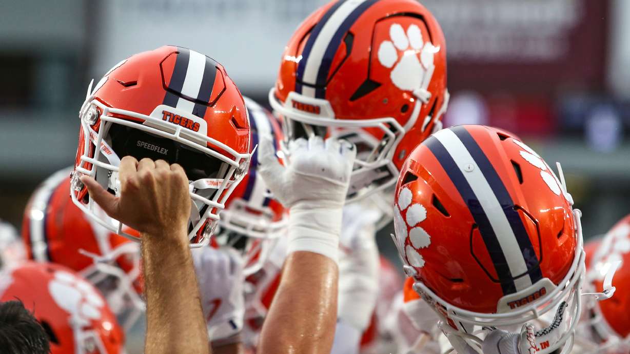 FILE - Clemson players lift their helmet before an NCAA football game against Florida State, Oct. 5, 2024, in Tallahassee, Fla.