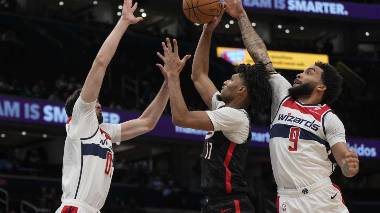 Portland Trail Blazers guard Shaedon Sharpe (17) goes up to shoot as Washington Wizards forwards Tristan Vukcevic (00) and Justin Champagnie (9) defend during the first half of an NBA basketball game, Wednesday, Feb. 26, 2025, in Washington.