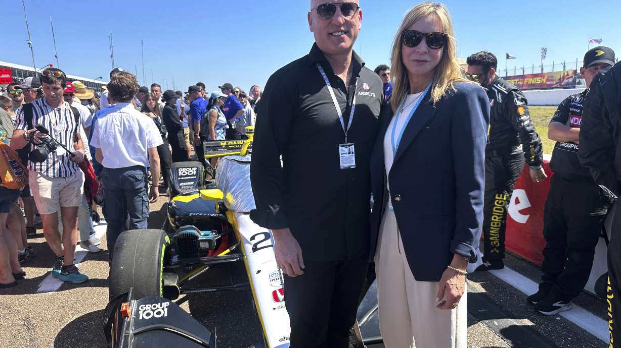 Dan Towriss, the new owner of Andretti Global, and Jill Gregory, president of Andretti Global, stand in front of Colton Herta's race car before the season-opening race, Sunday, March 2, 2025, in St. Petersburg, Fla.