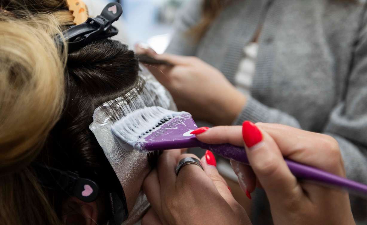 Hair design apprentice Kambrie Mustain brushes dye into a client's hair at Shade Nine Salon in American Fork on Thursday.