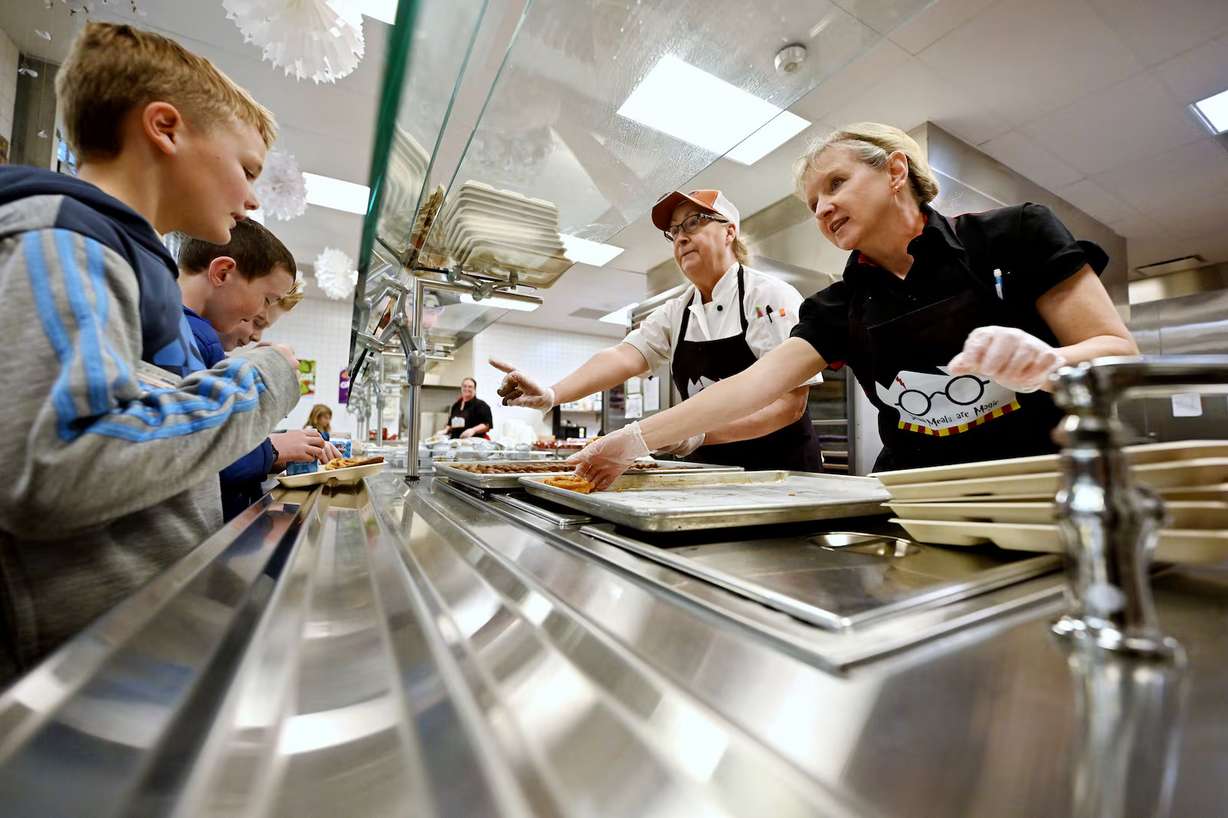 Debbie Gilstrap, kitchen manager, and nutrition worker Stephanie Anderson serve food to kids at Butler Elementary school in Cottonwood Heights on Jan. 28.