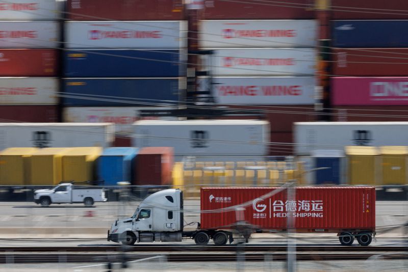 Vehicles drive past shipping containers from China at the China Shipping (North America) Holding Company Ltd. facility at the Port of Los Angeles in Wilmington, Calif., Feb. 4.