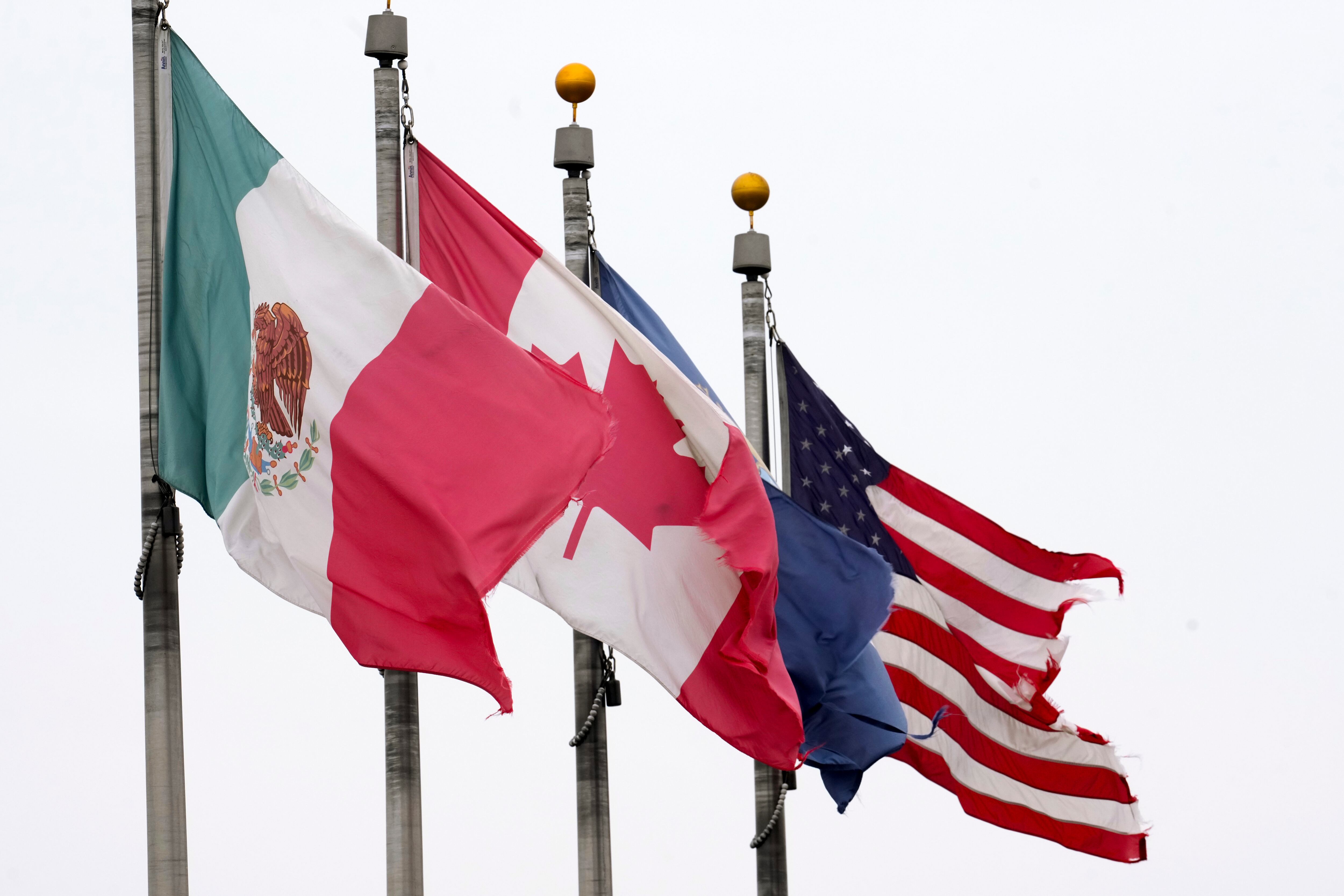 The flags of Mexico, Canada and the United States are shown near the Ambassador Bridge, Monday in Detroit. New 25% trade tariffs on goods from Canada and Mexico went into effect early Tuesday. What does that mean for Utah?