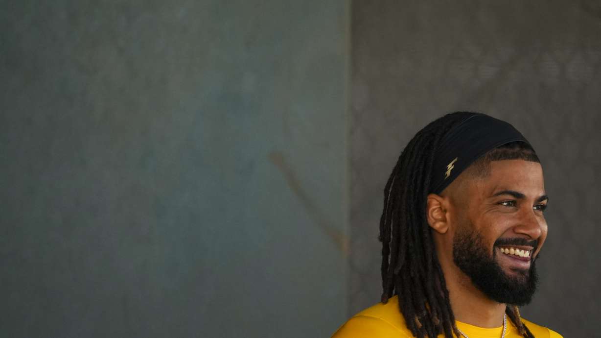 San Diego Padres' Fernando Tatis Jr. smiles while watching a bullpen session during spring training baseball practice at the team's training facility Saturday, Feb. 15, 2025, in Peoria, Ariz.