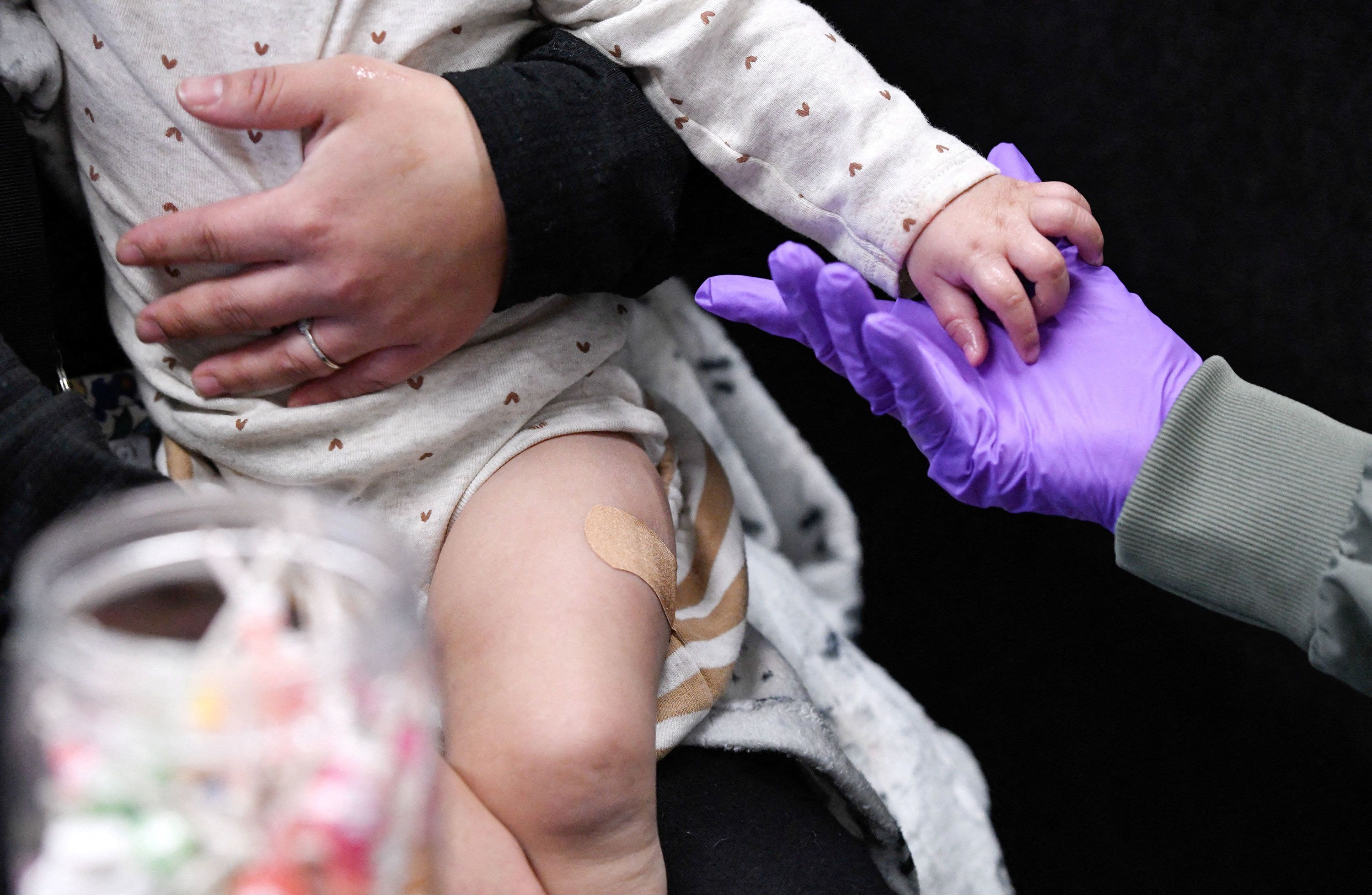 Sherry Andrews, right, holds a 13-month-old's hand after administering the first MMR vaccine dose to the child at the City of Lubbock Health Department in Lubbock, Texas, on Feb. 27. The CDC is in Texas responding to the outbreak.