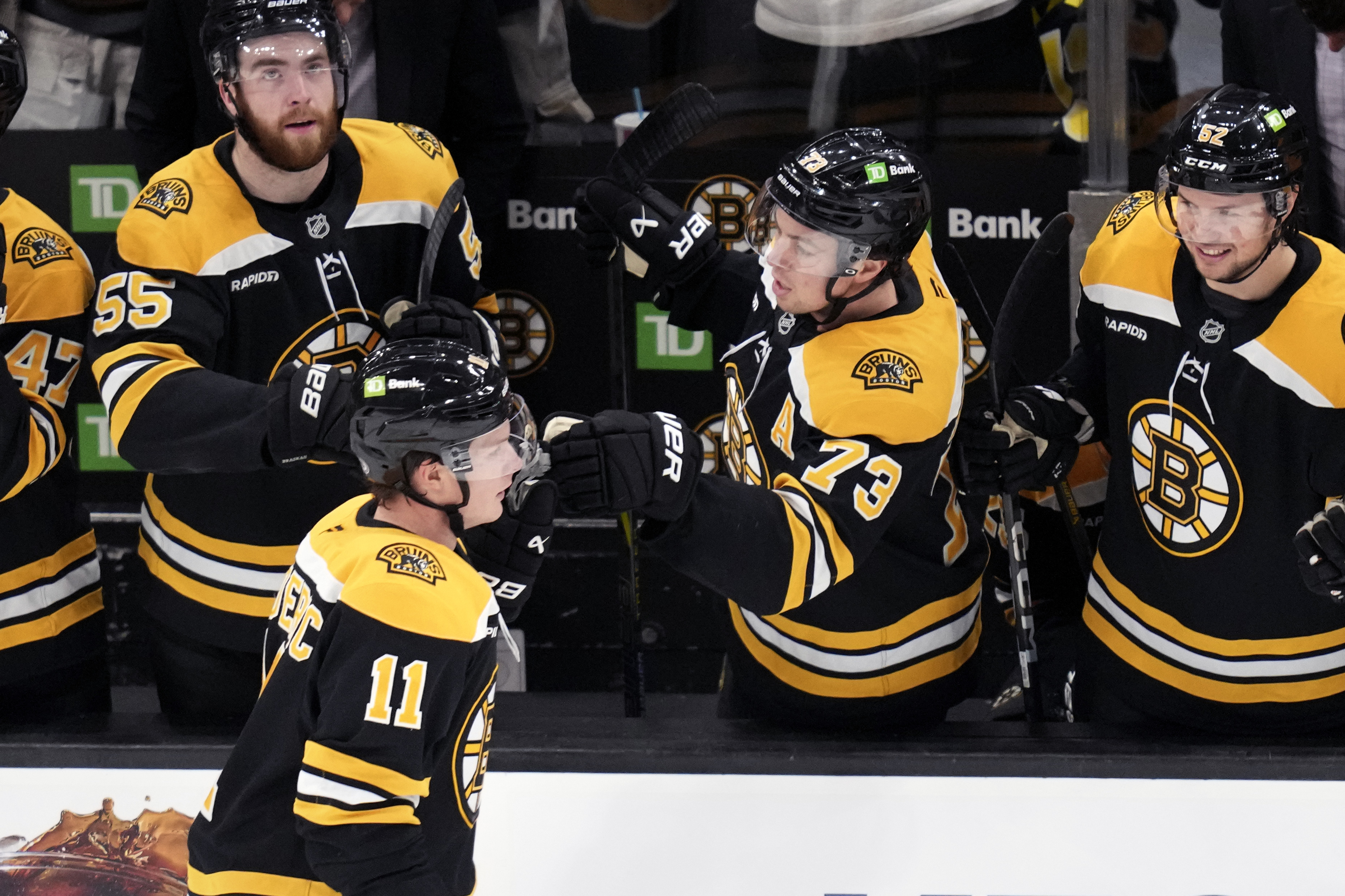 Boston Bruins center Trent Frederic (11) is congratulated after his goal against the Minnesota Wild during the second period of an NHL hockey game, Tuesday, Feb. 4, 2025, in Boston. 
