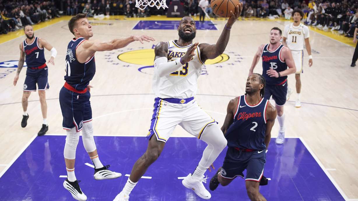 Los Angeles Lakers forward LeBron James, center, shoots as Los Angeles Clippers guard Bogdan Bogdanovic, second from left, and forward Kawhi Leonard defend during the first half of an NBA basketball game Sunday, March 2, 2025, in Los Angeles.