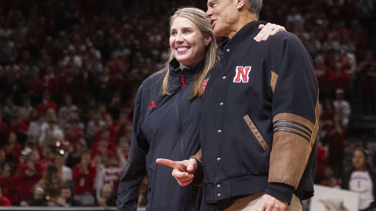 FILE - Newly named Nebraska volleyball head coach Dani Busboom Kelly, left, stands midcourt with retiring volleyball coach John Cook, right, during a timeout acknowledgment as Illinois plays against Nebraska in the first half of an NCAA college basketball game Thursday, Jan. 30, 2025, in Lincoln, Neb.