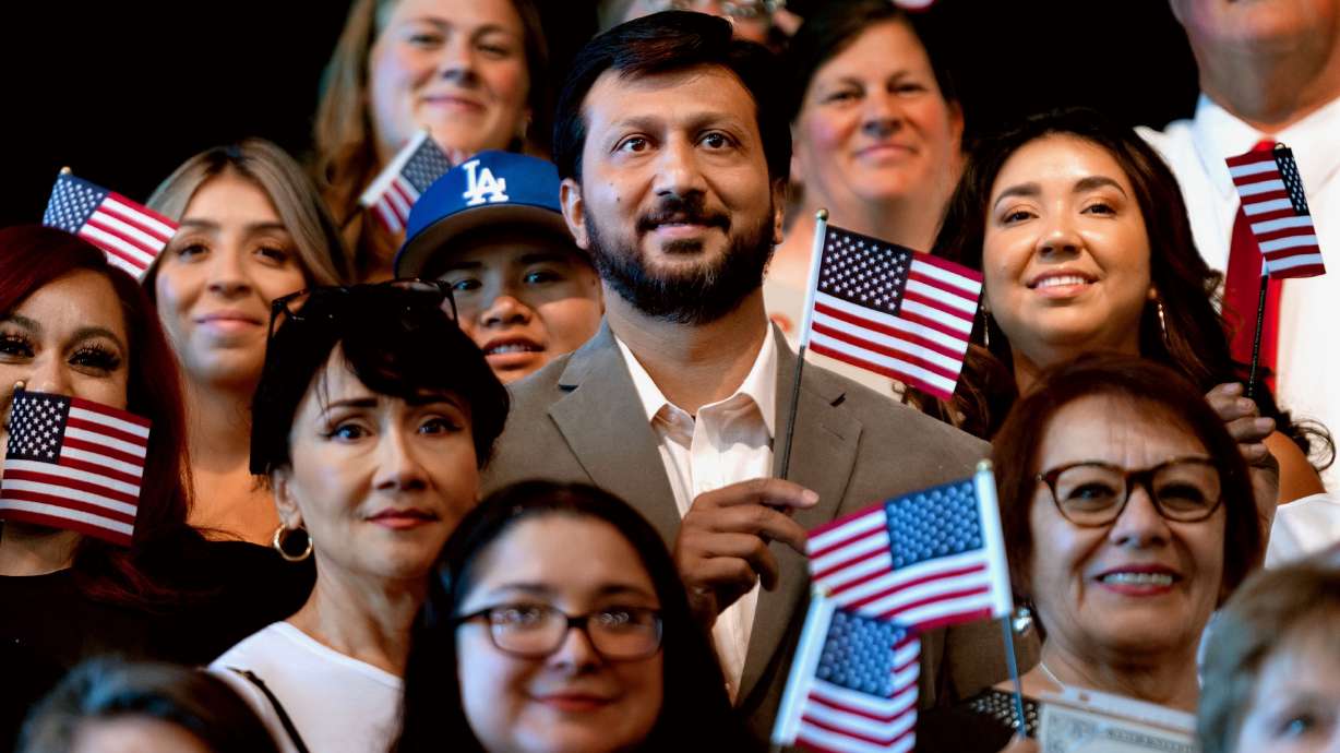 New U.S. citizens pose for a photograph following a naturalization ceremony in West Valley City on Sept. 13, 2024. A funding freeze is putting the ESL Center's citizenship program at risk.