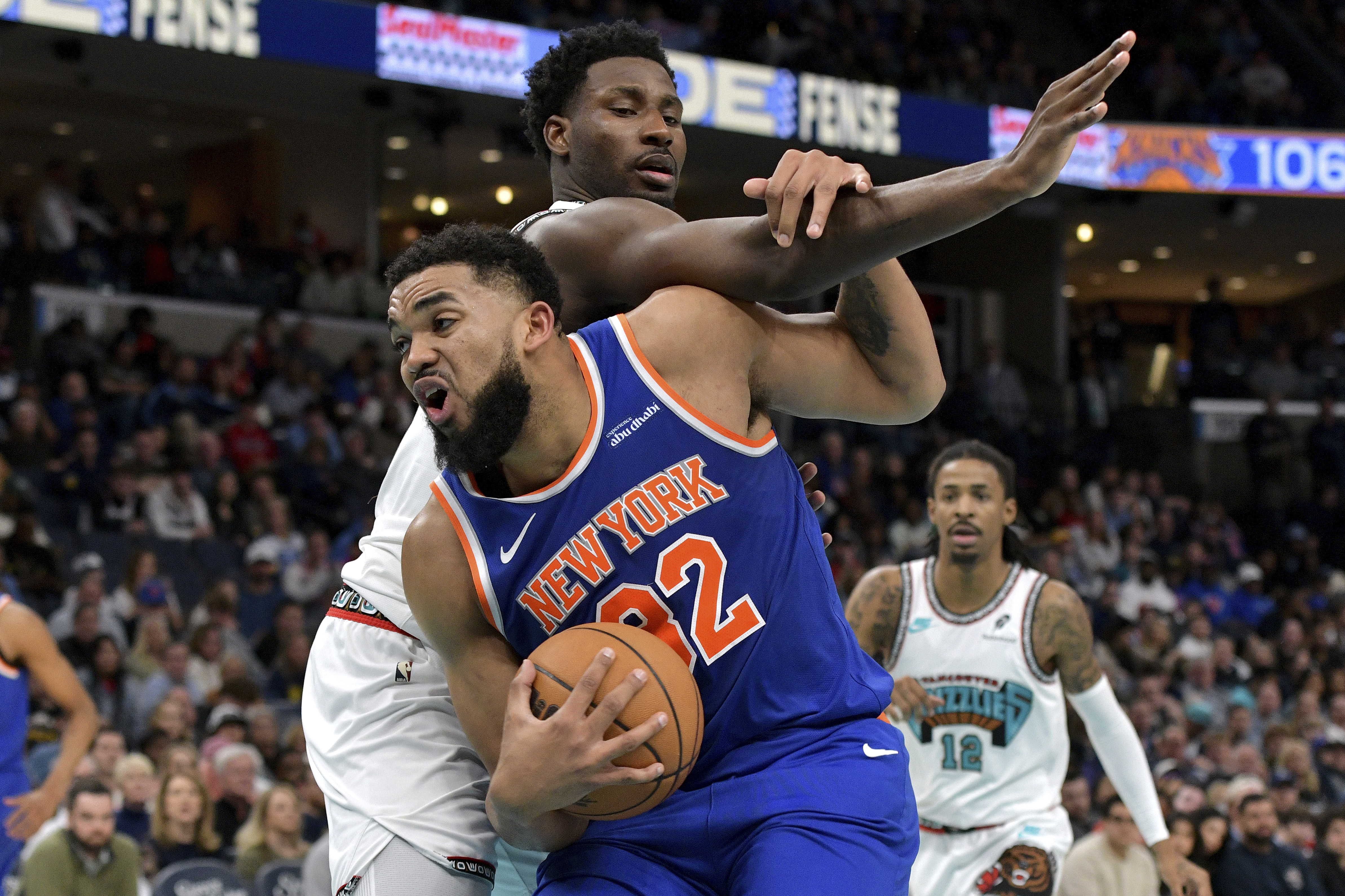 New York Knicks center Karl-Anthony Towns, front, handles the ball against Memphis Grizzlies forward Jaren Jackson Jr., top, in the second half of an NBA basketball game Friday, Feb. 28, 2025, in Memphis, Tenn. 