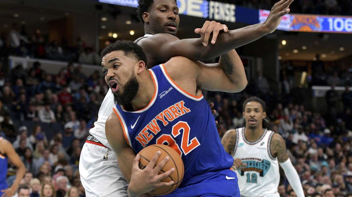 New York Knicks center Karl-Anthony Towns, front, handles the ball against Memphis Grizzlies forward Jaren Jackson Jr., top, in the second half of an NBA basketball game Friday, Feb. 28, 2025, in Memphis, Tenn.