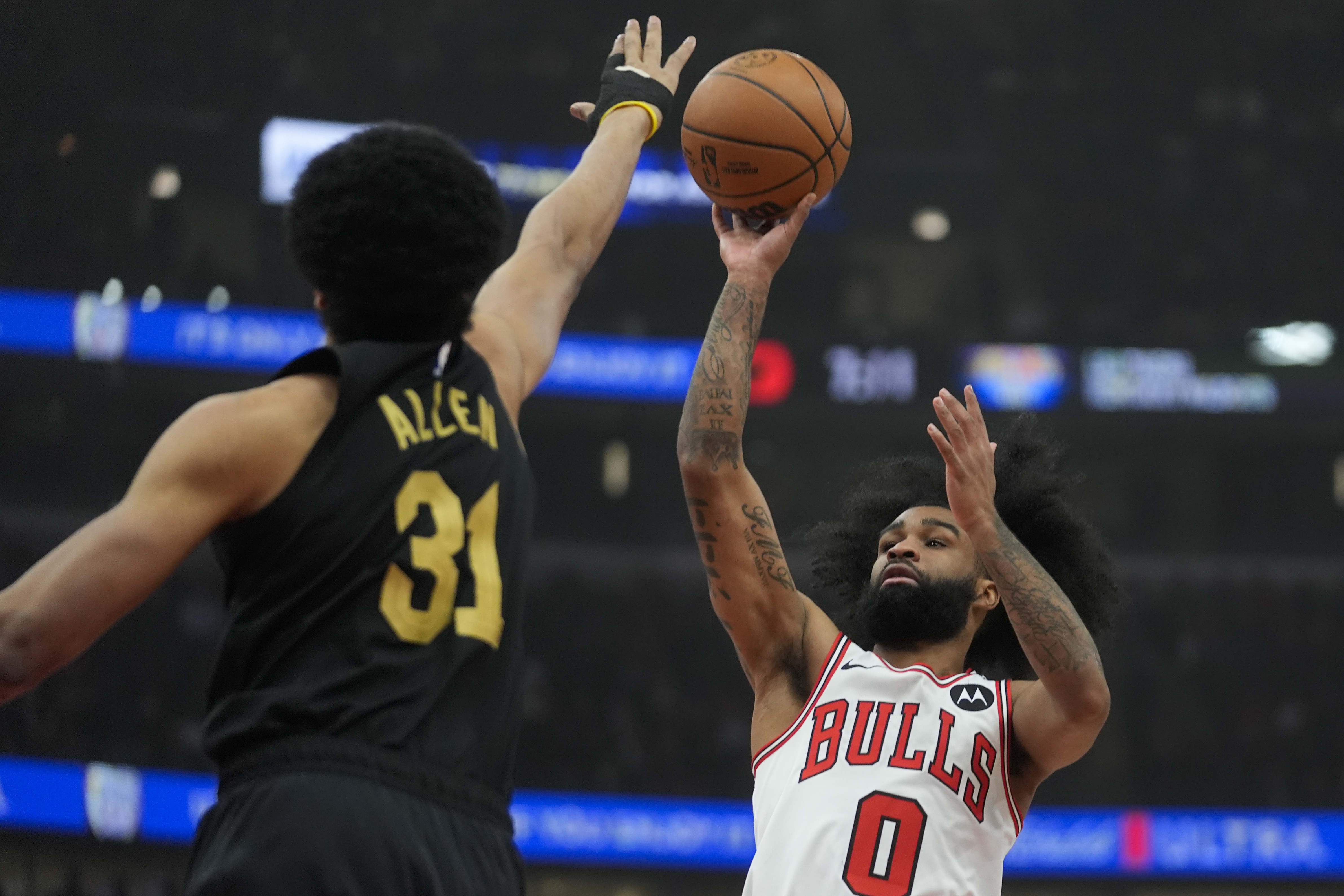 Cleveland Cavaliers center Jarrett Allen (31), left, tries to block Chicago Bulls guard Coby White (0) as he makes a shot during the first half of an NBA basketball game, Tuesday, March 4, 2025, in Chicago.