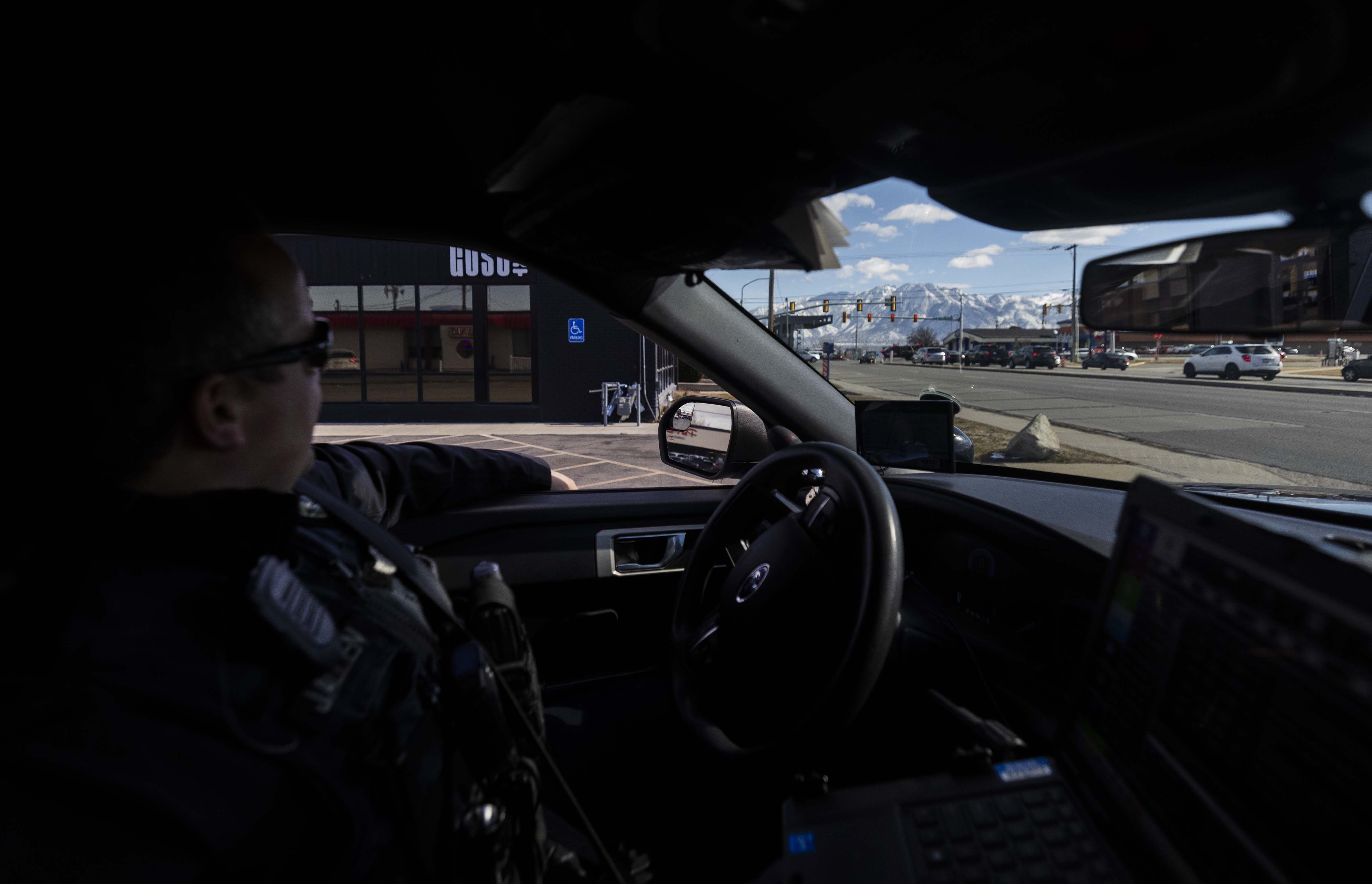 West Valley Police Officer Josh Allen watches a busy intersection for traffic violations in West Valley City on Feb. 12