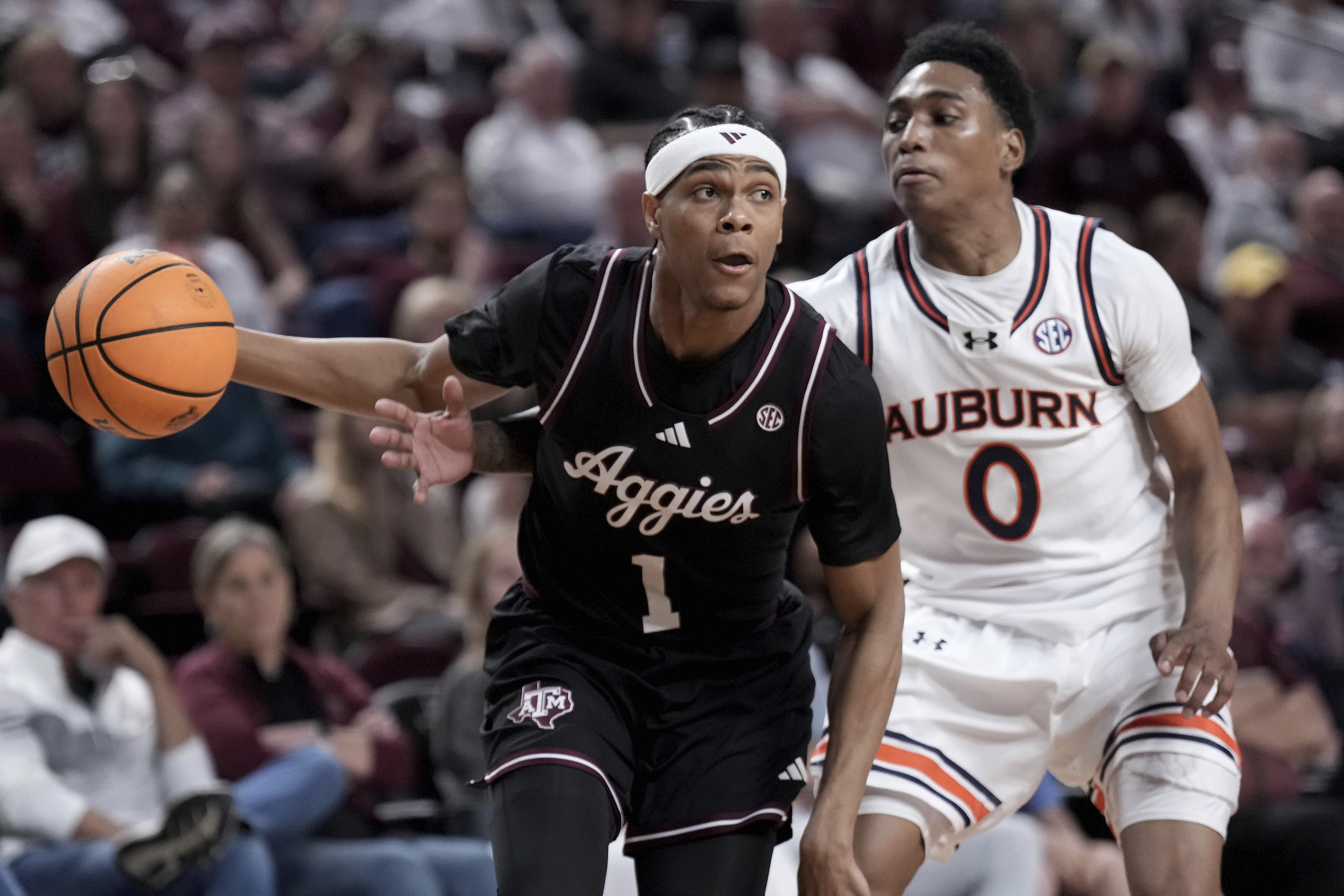 Auburn guard Tahaad Pettiford (0) tries to knock the ball away from Texas A&M guard Zhuric Phelps (1) during the first half of an NCAA college basketball game, Tuesday, March 4, 2025, in College Station, Texas. 