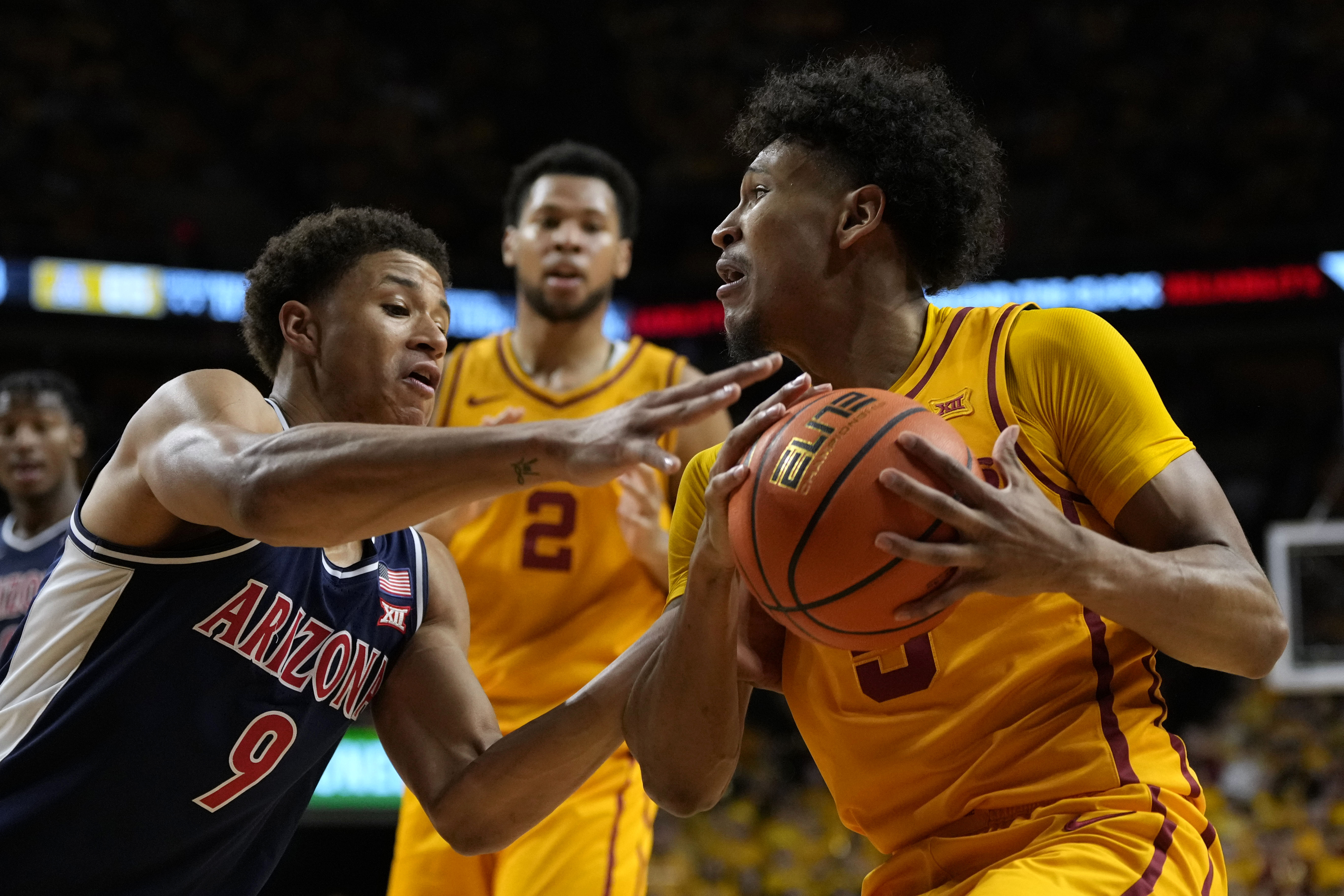 Iowa State guard Curtis Jones, right, is fouled by Arizona forward Carter Bryant (9) while driving to the basket during the second half of an NCAA college basketball game Saturday, March 1, 2025, in Ames, Iowa. 
