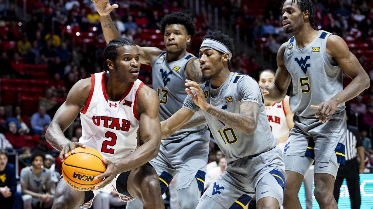 Utah Utes forward Ezra Ausar (2) controls the ball while guarded by West Virginia Mountaineers guard Sencire Harris (10) during an NCAA men’s basketball game held at the Huntsman Center in Salt Lake City on Tuesday, March 4, 2025.