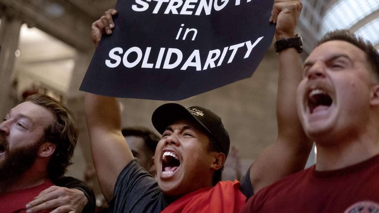 Professional Firefighters of Utah members Donavan Minutes, Branden Cresencia and Bennett Lloyd chant at a rally in opposition to HB267 at the Capitol in Salt Lake City on Feb. 7.