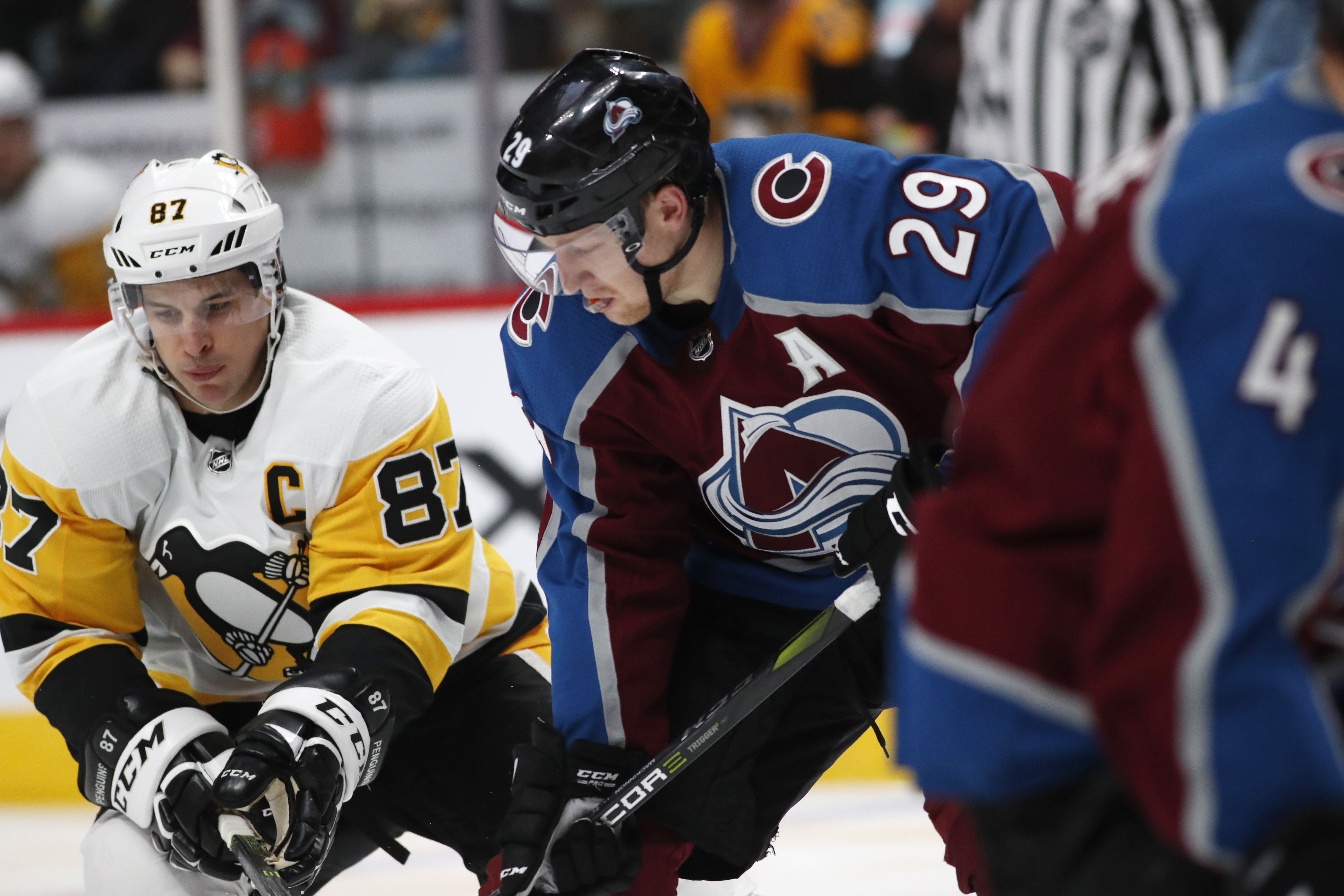 FILE - In this Dec. 18, 2017, file photo, Pittsburgh Penguins center Sidney Crosby, left, jostles with Colorado Avalanche center Nathan MacKinnon for control of the puck during the third period of an NHL hockey game in Denver.