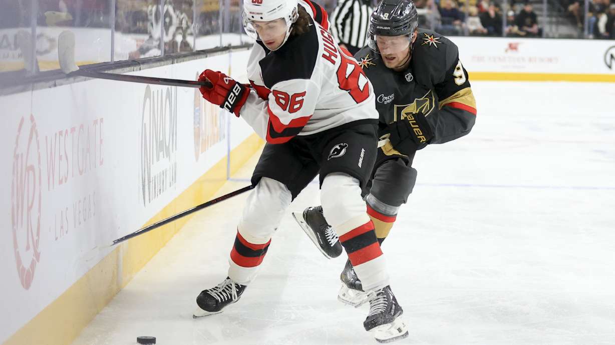 New Jersey Devils center Jack Hughes (86) and Vegas Golden Knights center Jack Eichel (9) battle for the puck during the first period of an NHL hockey game Sunday, March 2, 2025, in Las Vegas.