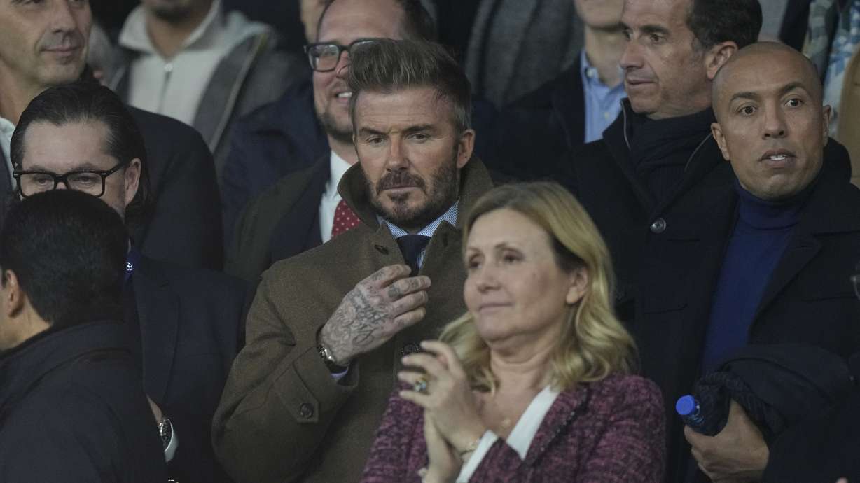 Former England soccer player David Beckham, center, takes his place in the stands before the Champions League round of 16 first leg soccer match between Paris Saint-Germain and Liverpool at the Parc des Princes in Paris, Wednesday, March 5, 2025.